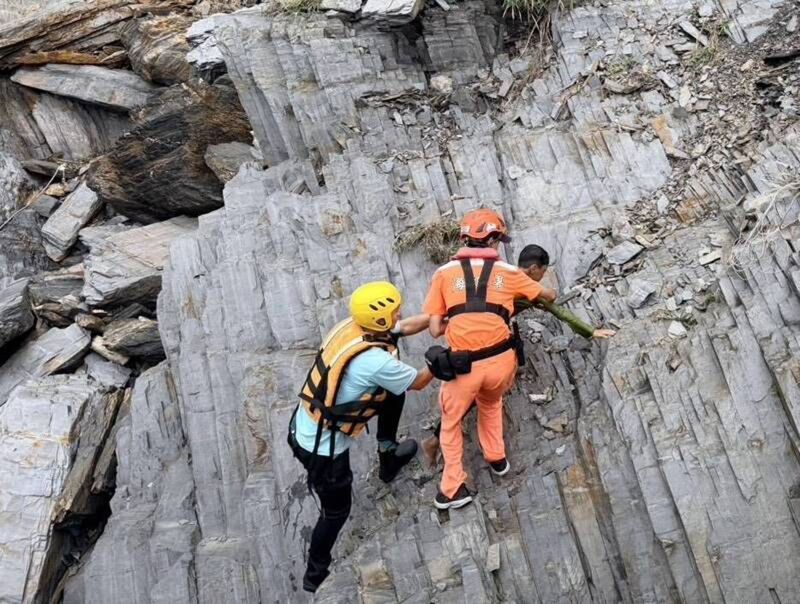 海巡隊員及消防員協力把男童拉上岸邊。讀者提供