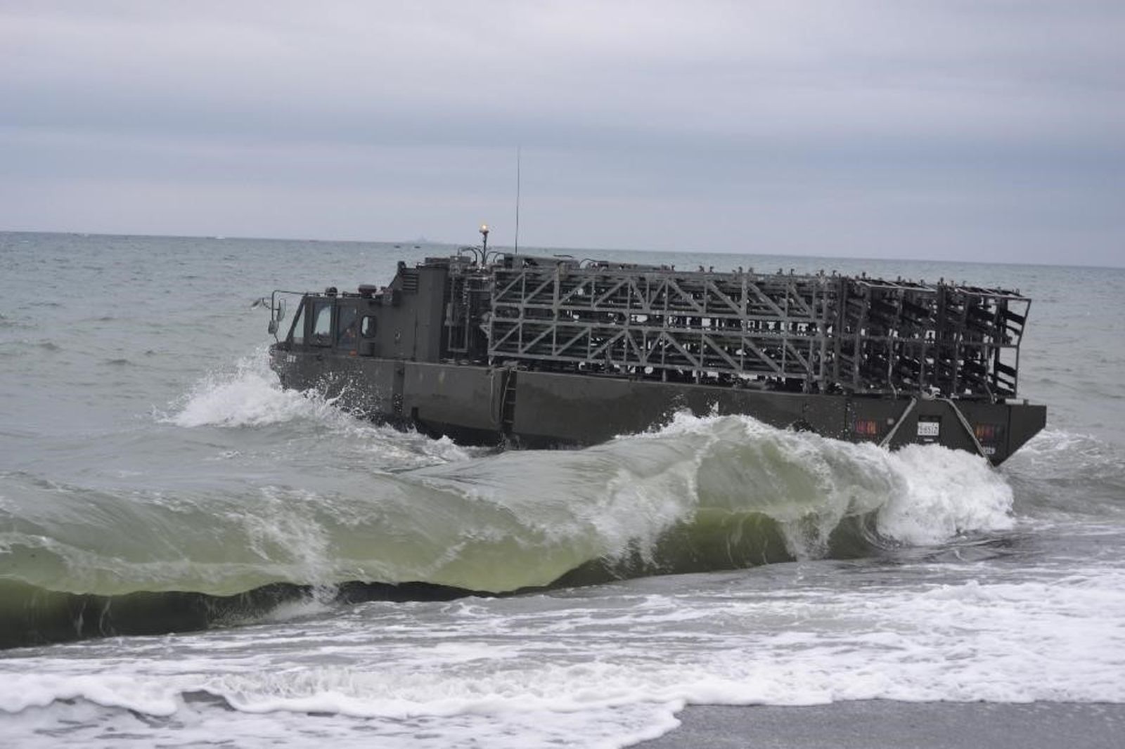 94式水際地雷敷設裝置的兩棲布雷車，已經轉換成水中布雷艇的型態，並放上水雷施放架，準備下水進行布雷操演。圖片取自維基百科