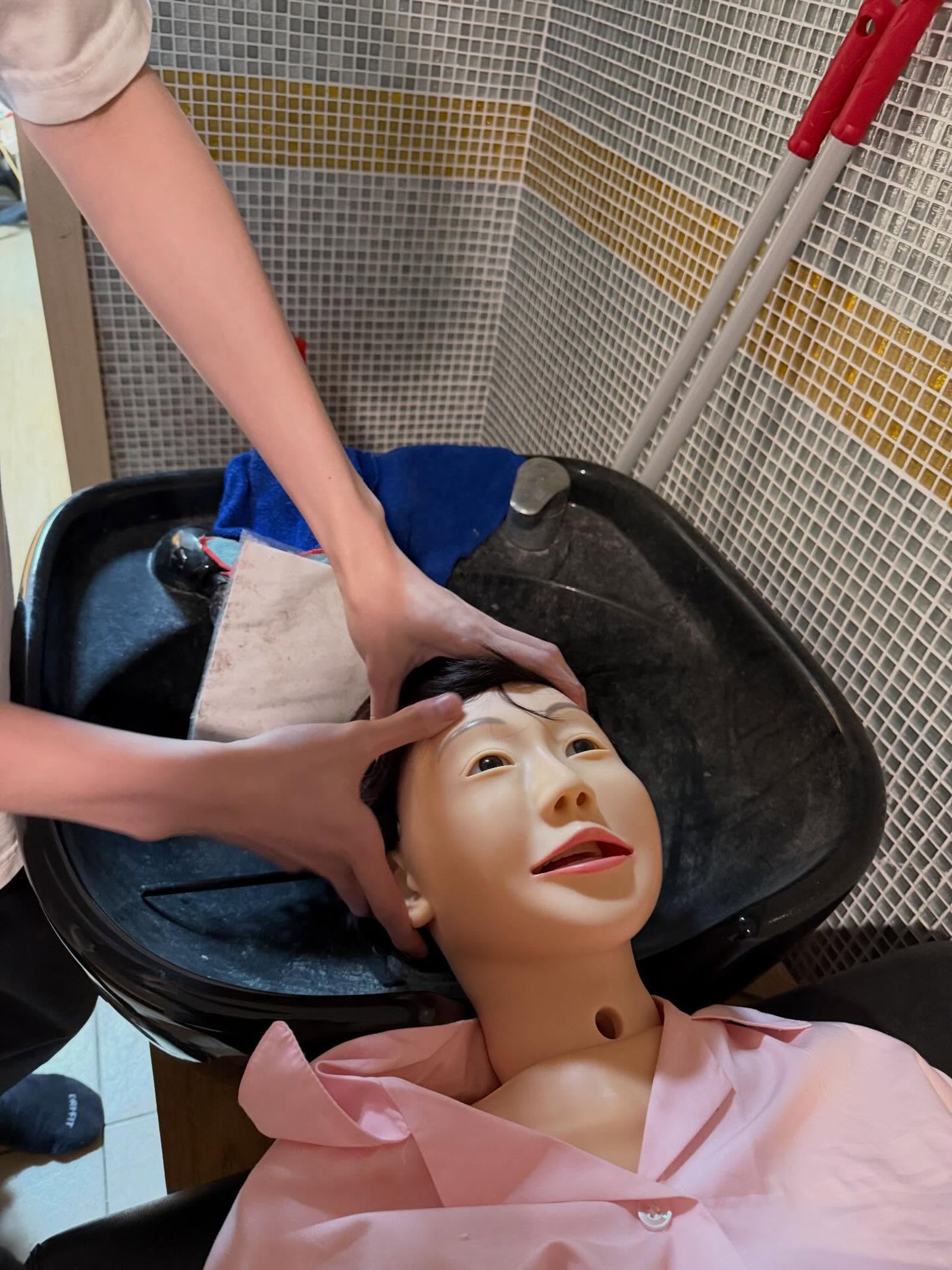 民眾分享練習洗頭的畫面,假人頭的外貌是否神似台中市長盧秀燕,網路引發不少論戰。畫面授權threads xt_0414