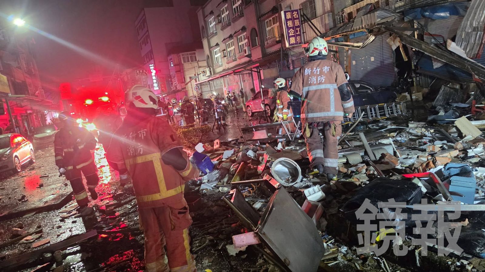 民宅磚牆與大量物品被氣爆威力噴炸到路面,麵包店夫婦受困在屋內,消防隊員展開搜救。翻攝fb郭朋鑫(高峰里里長)