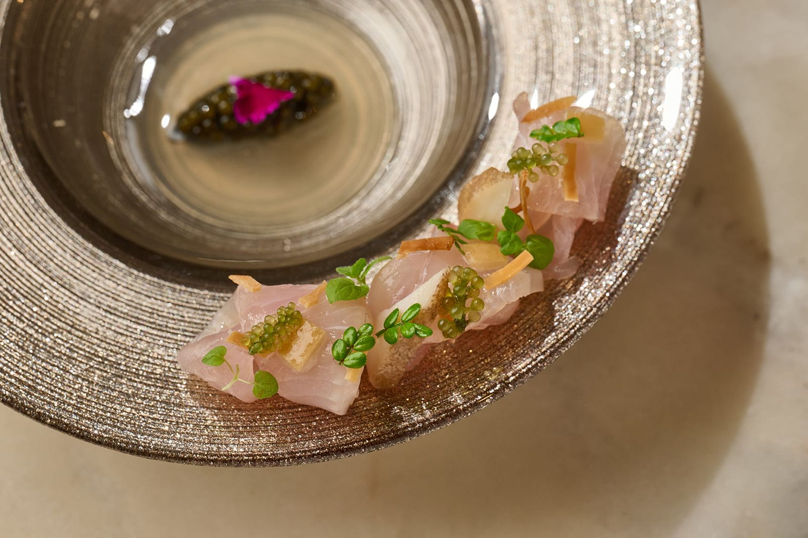 「鰤魚｜海螺｜發酵番茄」鰤魚與海螺交疊的生魚片，佐以發酵蕃茄和蛤蠣清湯製成的醬汁，兼具視覺跟味覺享受。（COAST供圖）