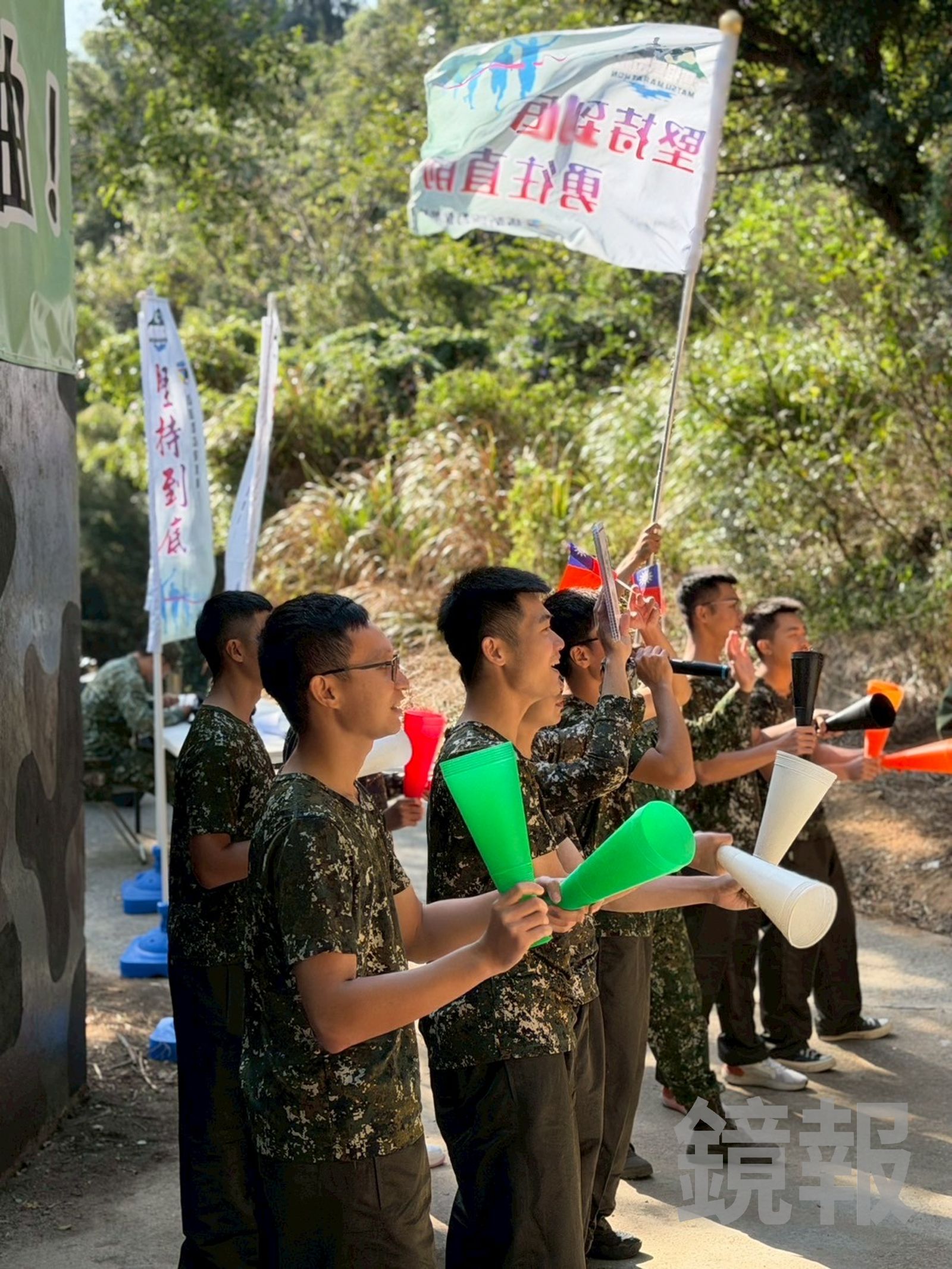 馬防部的官兵站在坑道口,為跑者搖旗加油。