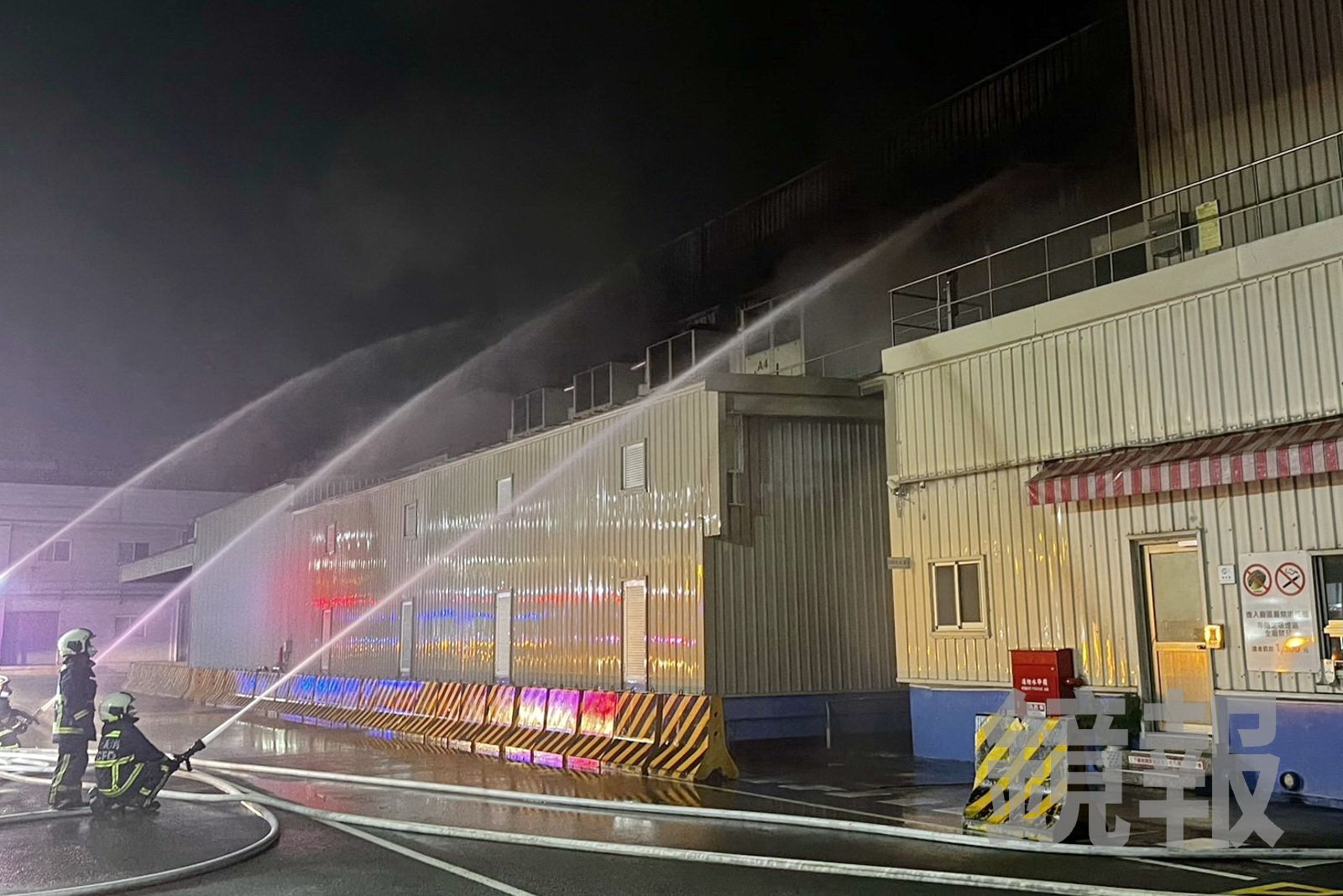 物流工廠鐵皮廠房陷入火海，消防隊射水防護，避免延燒。民眾提供