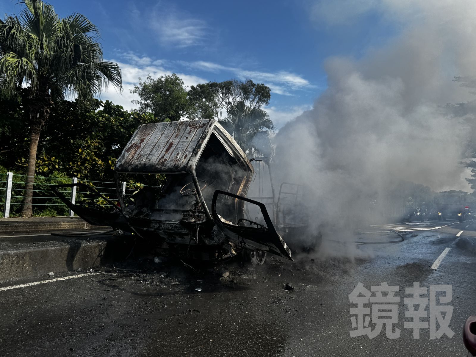 小貨車起火燒毀,冒出陣陣濃煙,消防隊員持續射水灌救。圖/攝影林建鋒