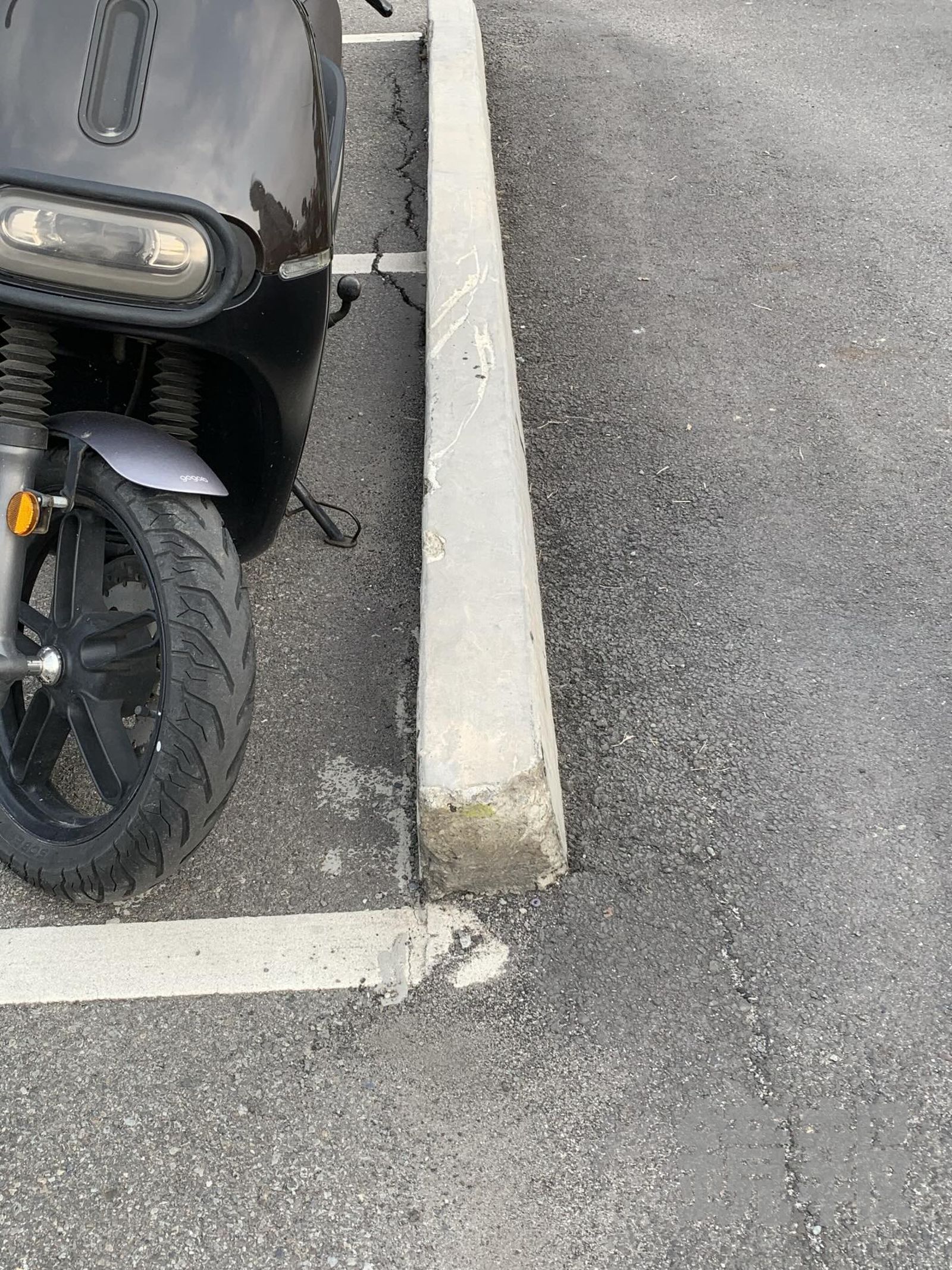 台中馬卡龍公園機車停車場有突起的灰白色緣石，沒有顯眼的顏色塗裝，不易辨識。李小姐提供