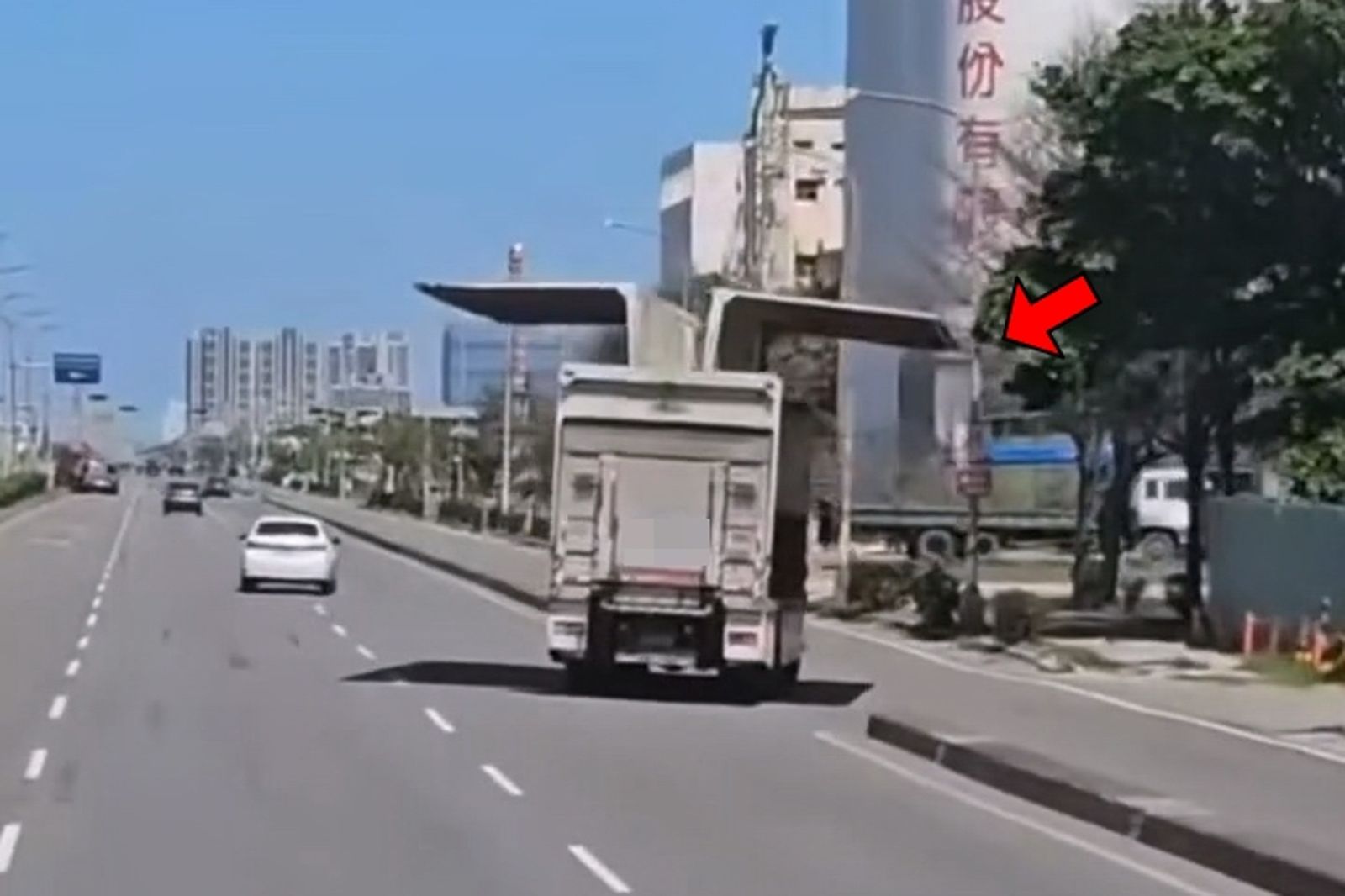 民眾目擊行駛中的大貨車後斗鷗翼未關,路燈桿(箭指處)瑟瑟發抖。畫面授權threads nm4l.09