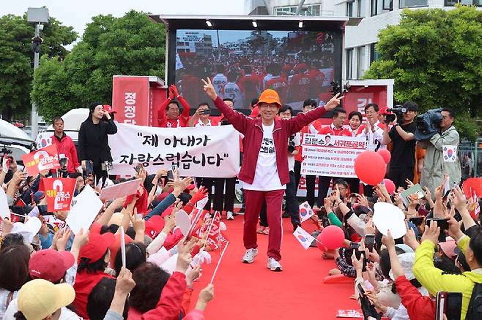 金文洙昨在濟州島造勢，也穿上朴寶劍劇中常穿的紅色運動服。翻攝NAVER