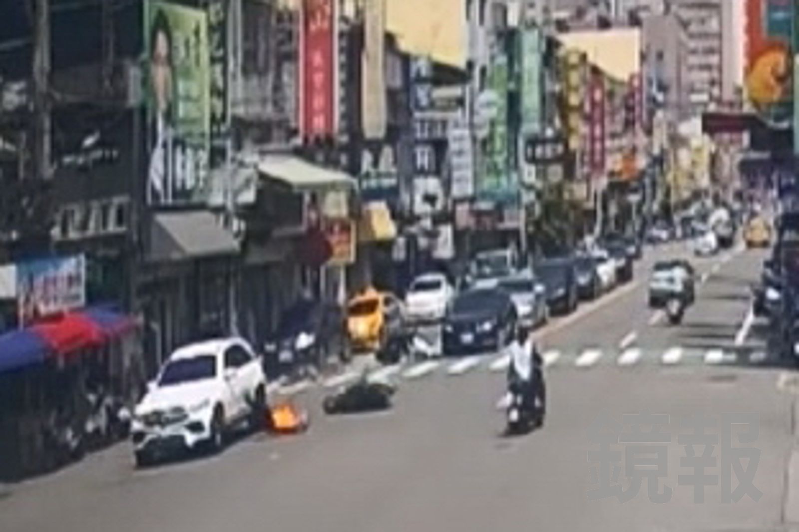 2名機車騎士在路口停等紅燈，慘遭白色進口休旅車從後追撞，其中1人被拋上引擎蓋後再重摔落地。民眾提供