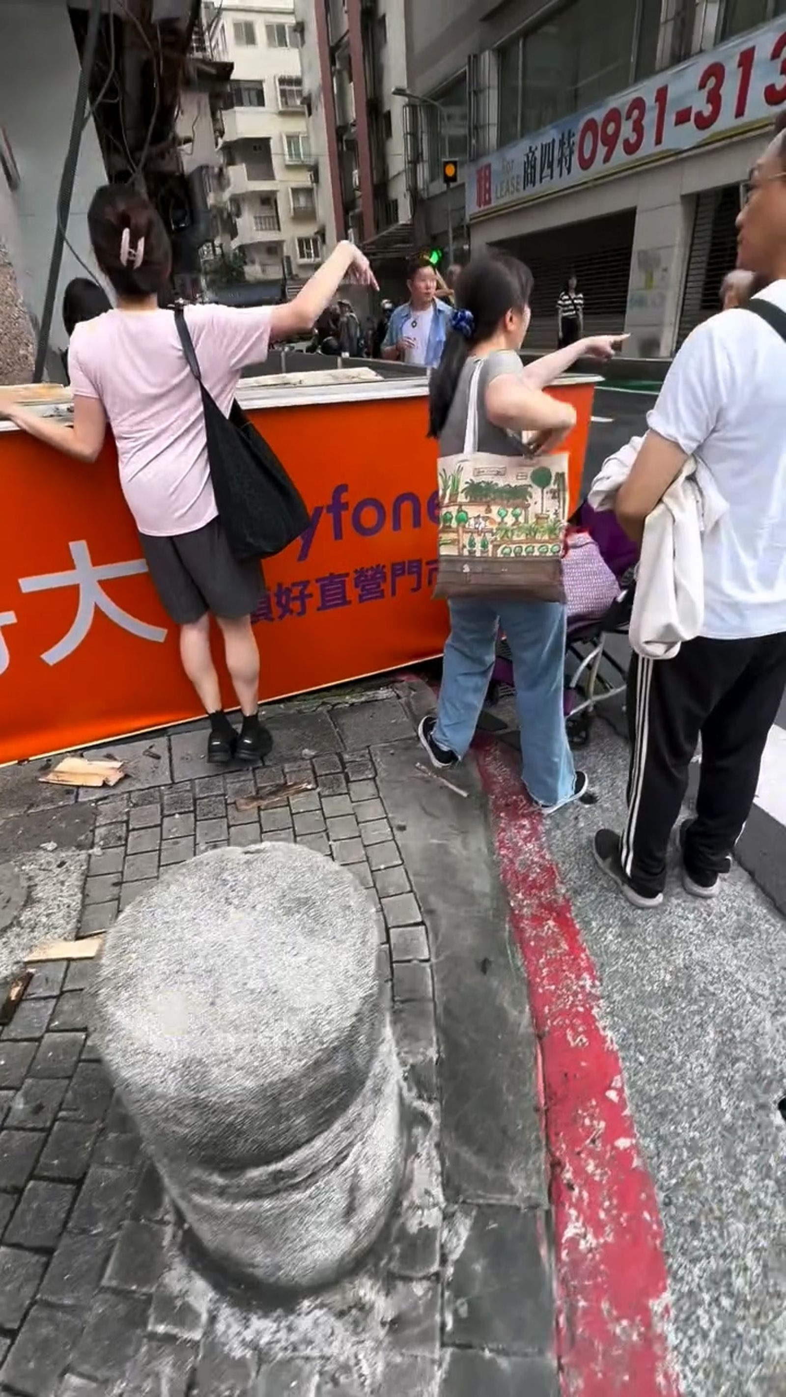 北市東區頂好商圈電信公司的廣告招牌突然掉落，當場砸中路過的婦人，民眾焦急關切其傷勢。畫面翻攝threads kaoya_nan.hai
