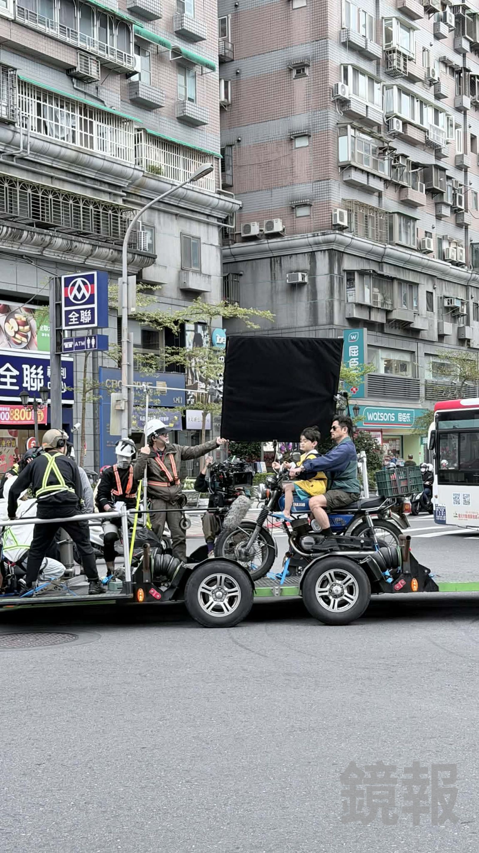 郭富城騎著機車，與小童星在景美街頭拍攝。讀者提供