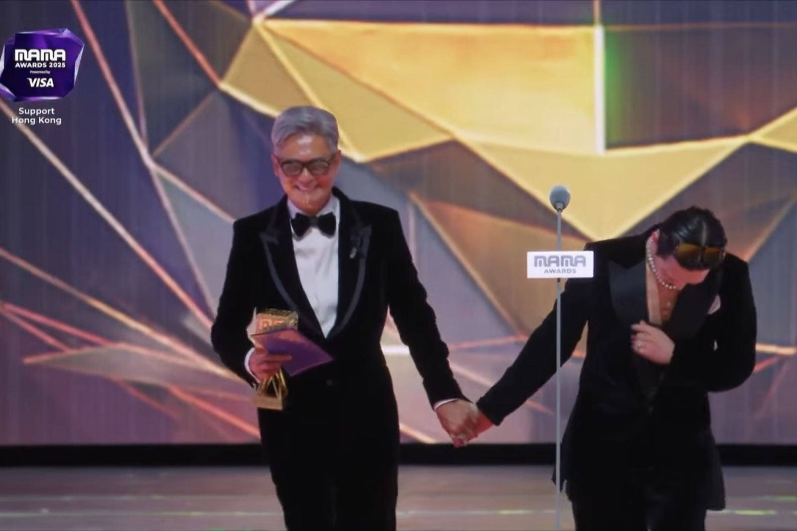 周潤發(左)頒獎時牽著GD的手,讓天王超害羞。翻攝Mnet