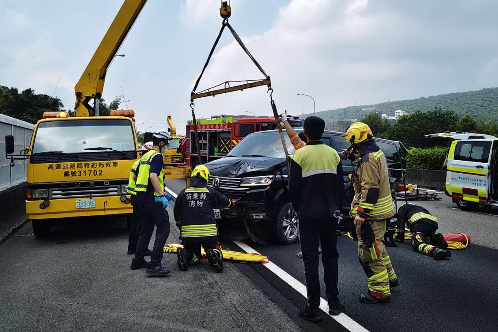 拖吊車將商旅車吊起，消防隊員查看是否有人員受困待救。民眾提供