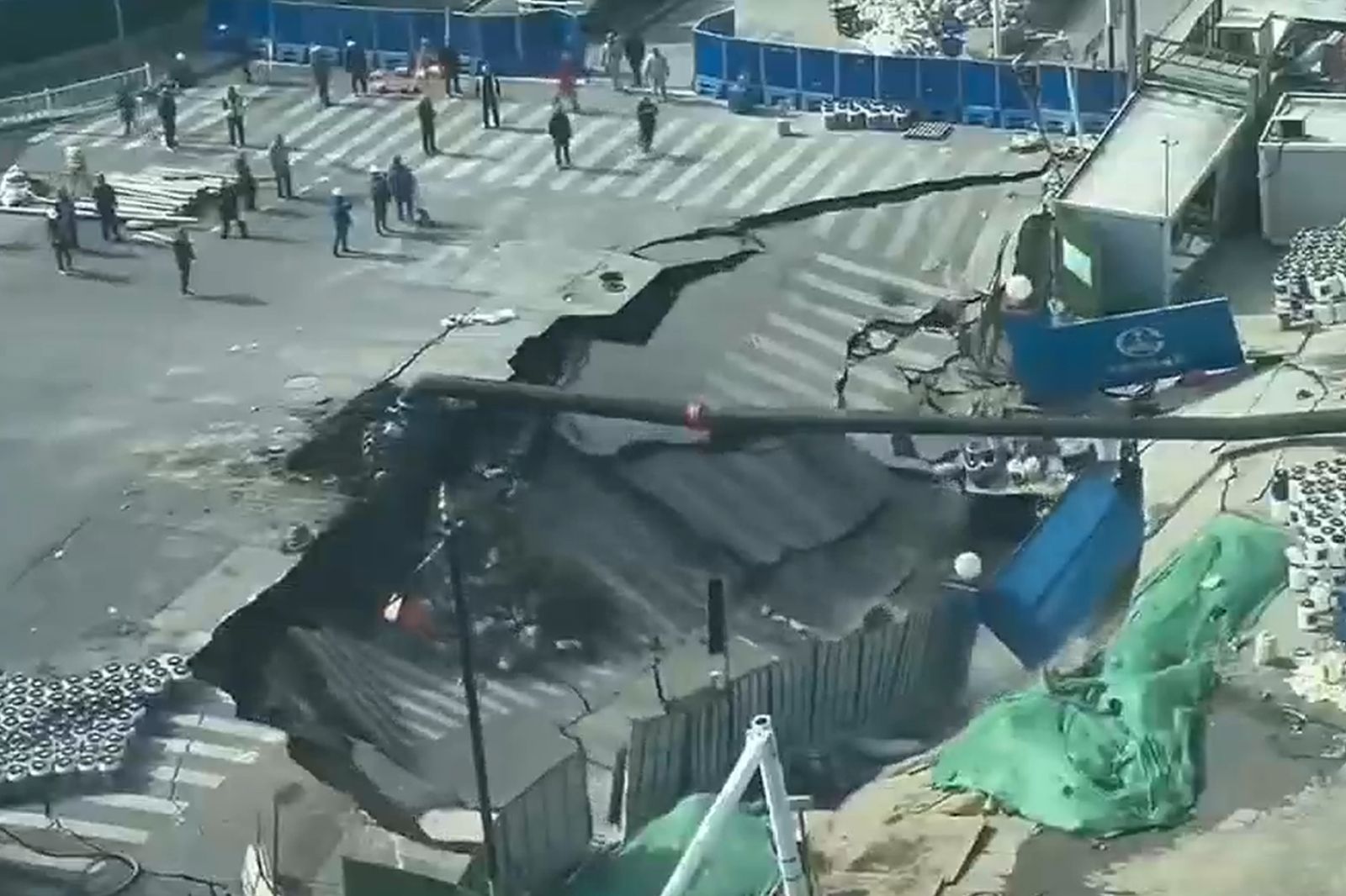 路面開始坍塌，工程人員都還在一旁觀看。圖／微博