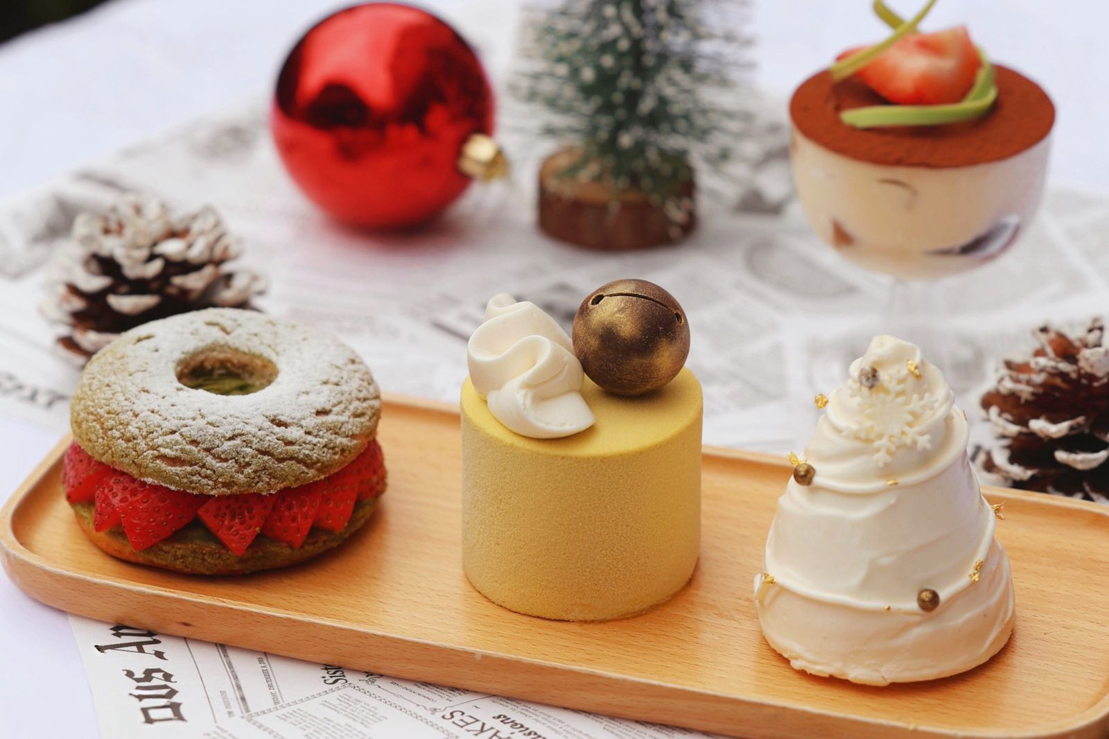 「白雪聖誕樹」以海綿蛋糕堆疊巧克力脆片與焦糖胡桃，外層白巧克力慕斯包覆，甜中帶脆。（圖右，200元／個，老爺小花園供圖）