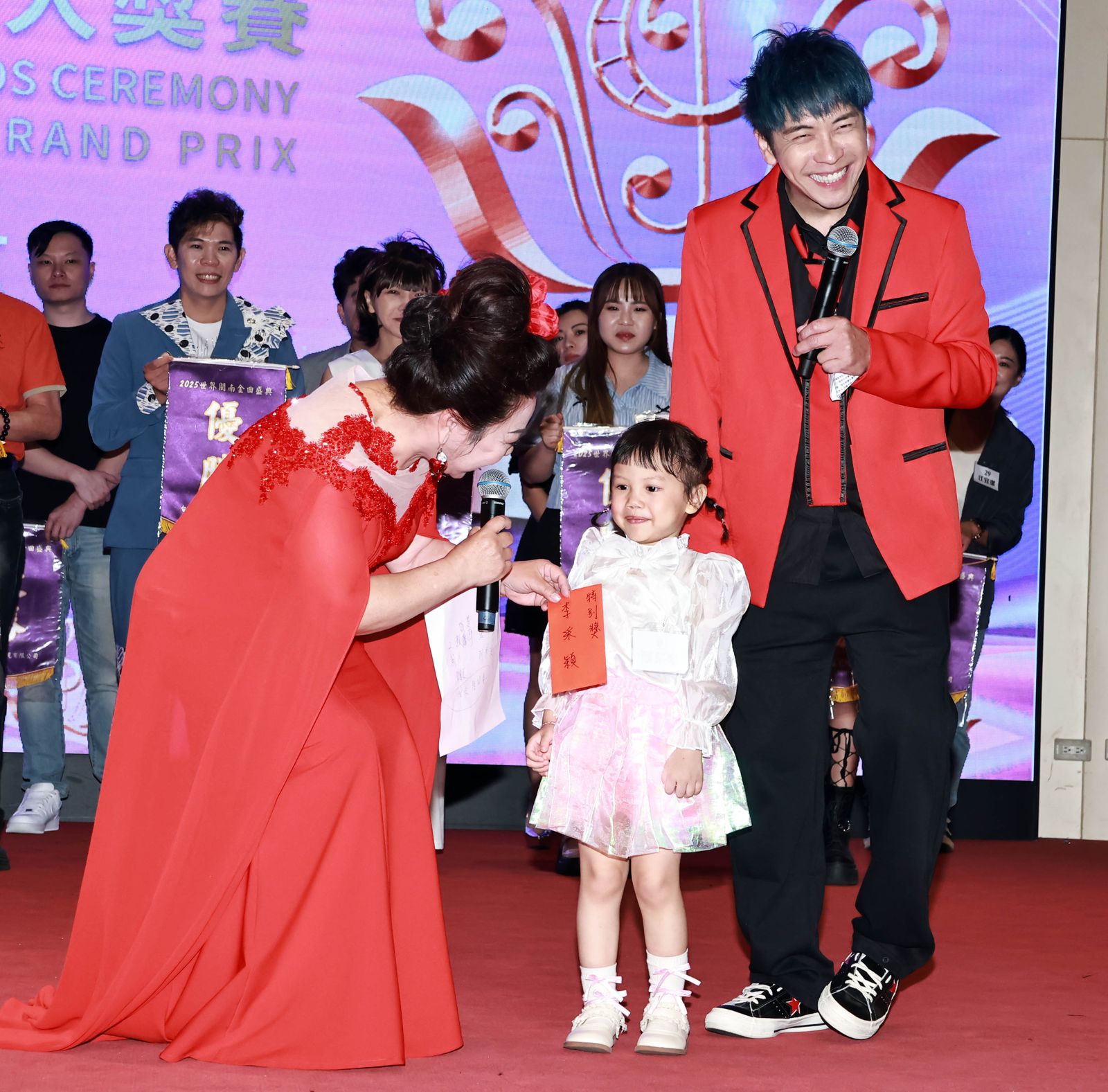 白冰冰(左起)臨時包紅包送給4歲的小朋友當特別獎,主持人東諺也笑得很開心。長興影視提供