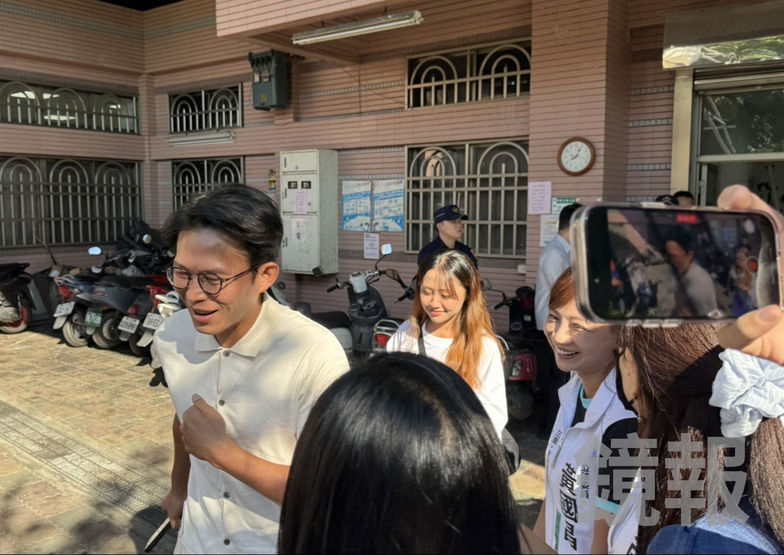 黃國昌面帶微笑地和團隊叮嚀投完票後手上要蓋選舉章「要檢查」。(圖/李奇叡攝)