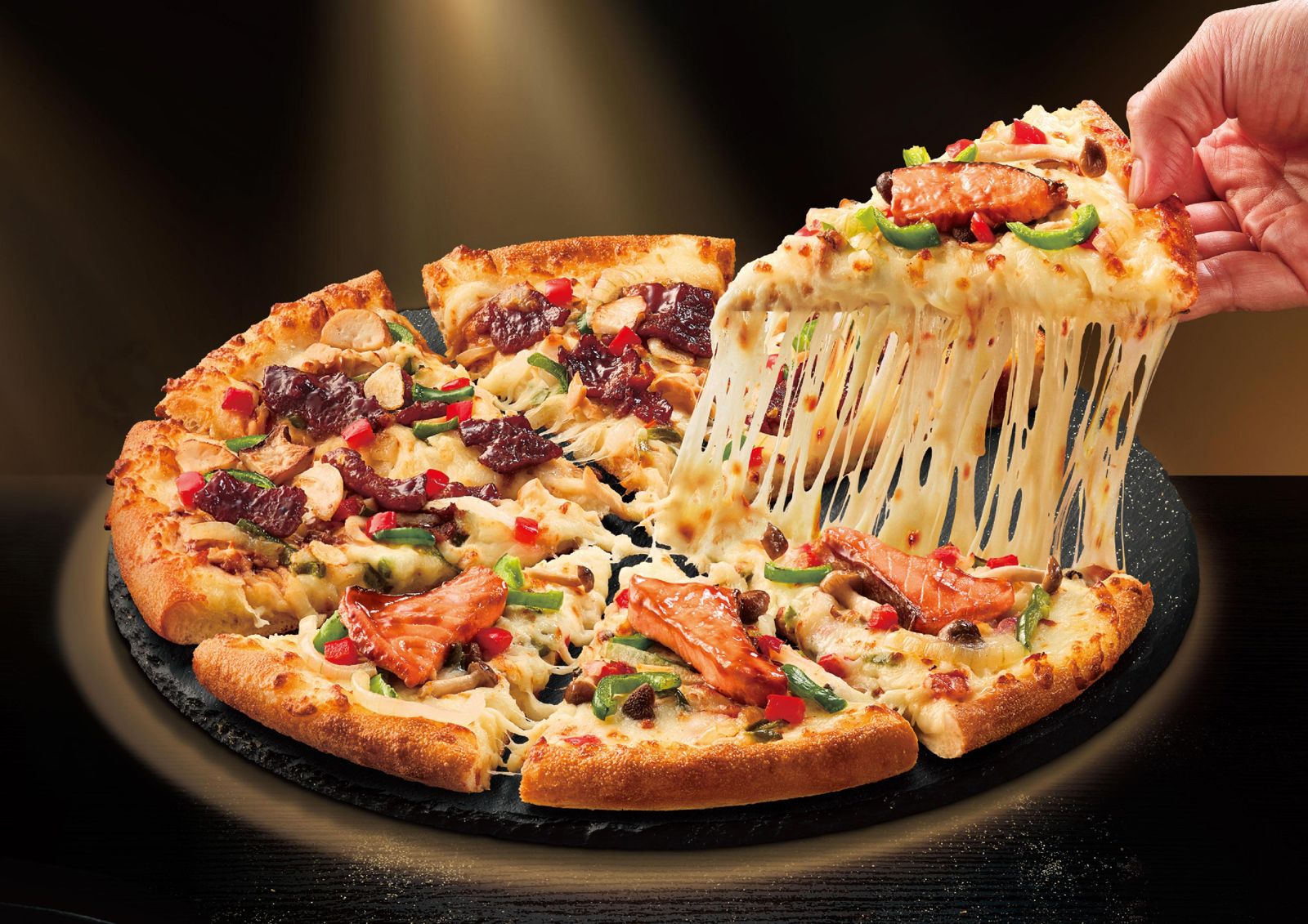 「頂鮭豪牛雙饗披薩」鋪滿炙烤頂級鮭魚肚與炭燒牛肉，一口咬下鹹香滿足。（459元／單點，達美樂供圖）