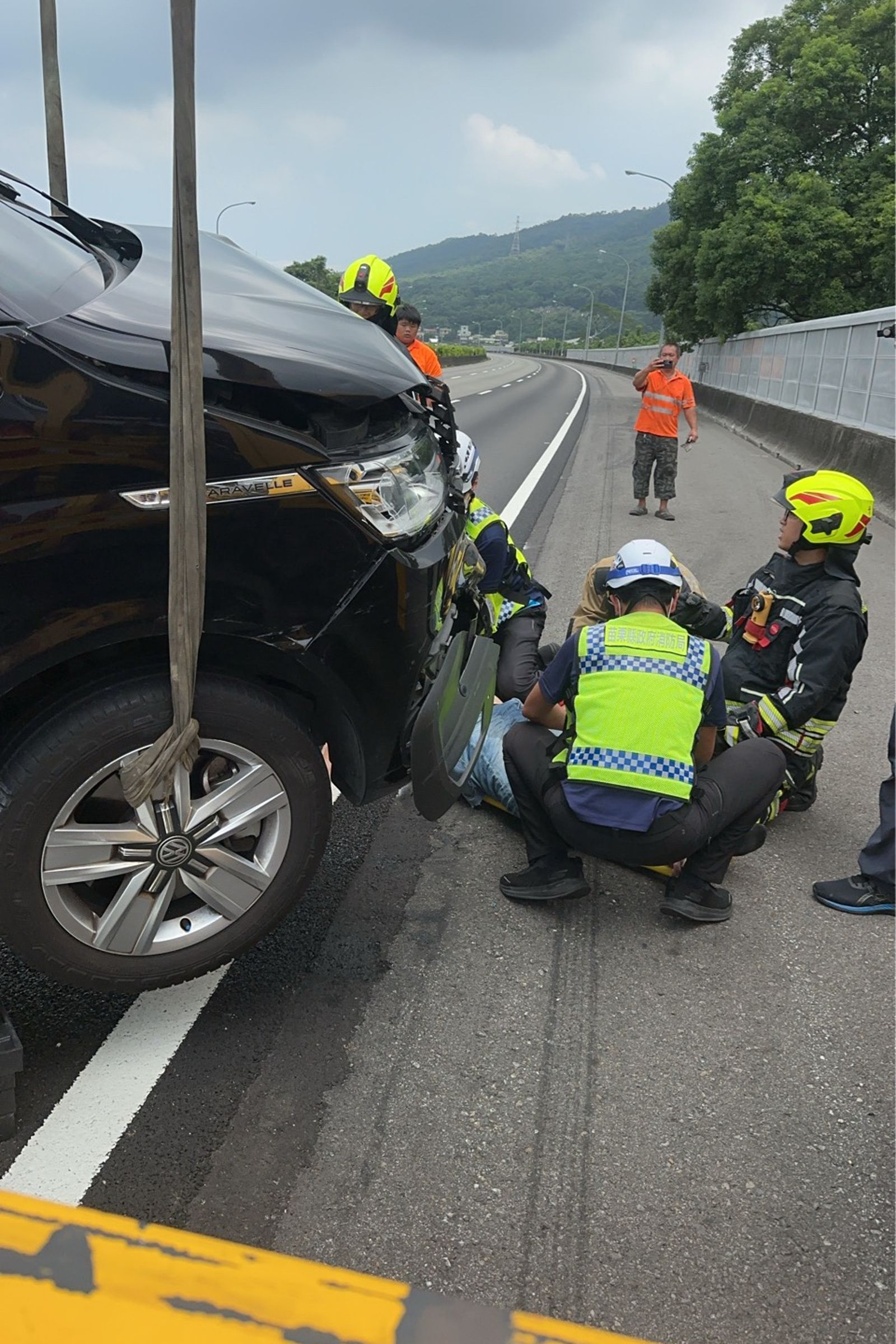 拖吊車將商旅車吊起，消防隊員為傷者進行檢傷、急救處置。民眾提供