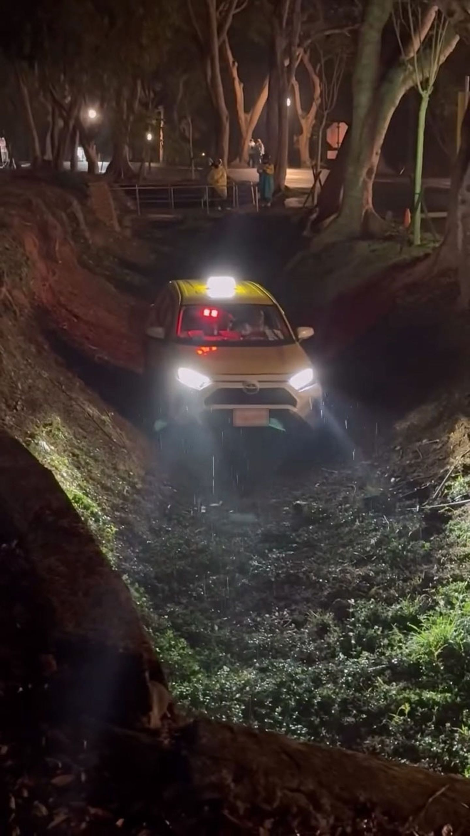 計程車深夜誤闖東海校園邊坡，困在一層樓深的坑洞內，還好溝底無水，無人受傷。翻攝 threads y.r_83