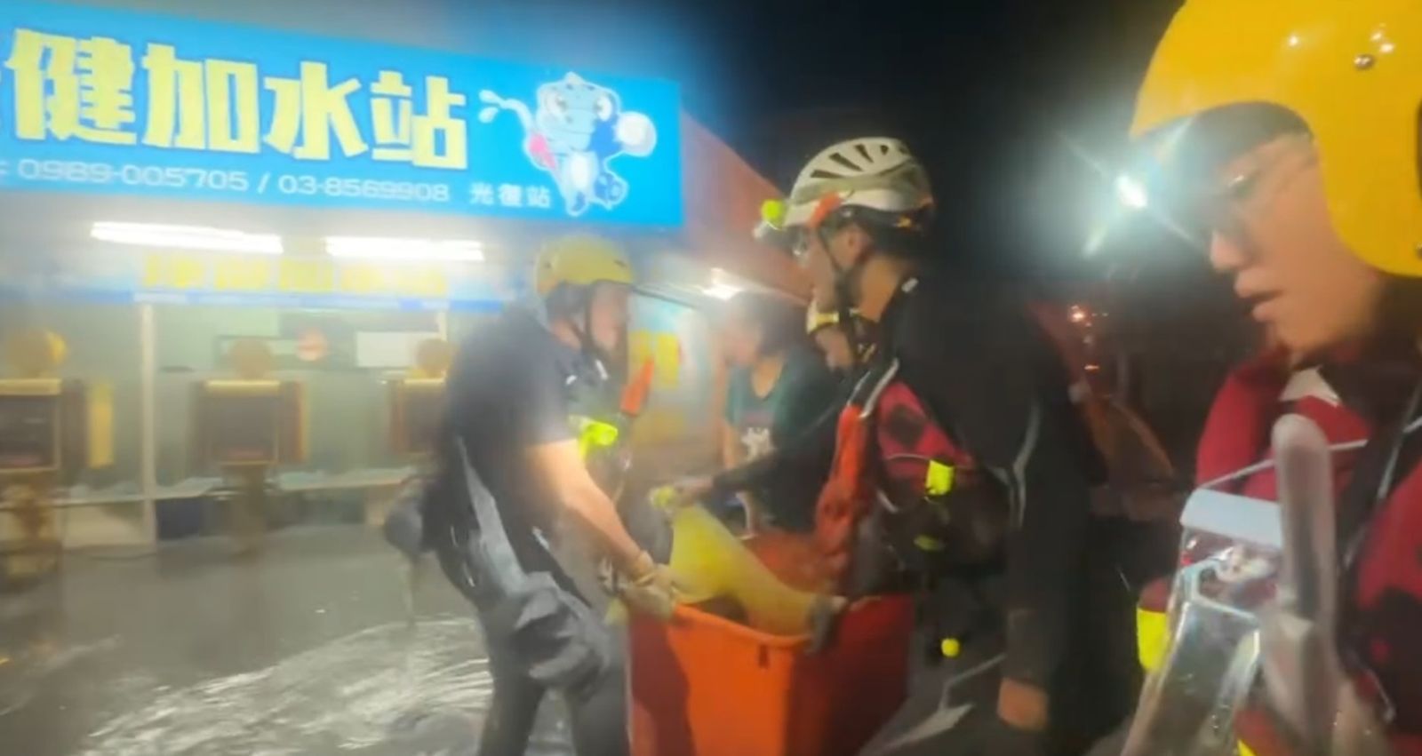 救難人員把受災幼童裝進大型橘色水桶,將他們從湍急的水流中脫困。圖/翻攝自LINE群組