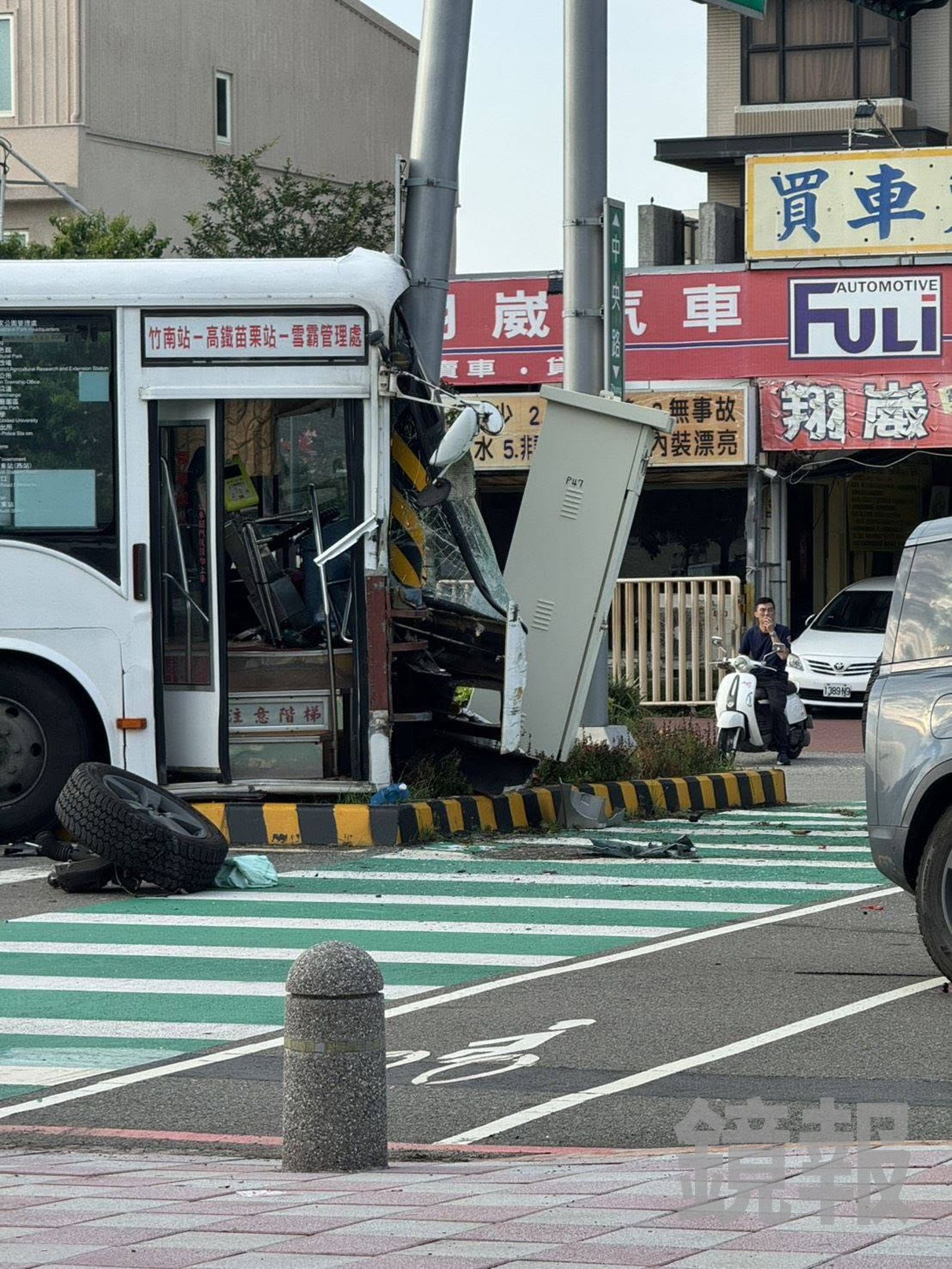 中央分隔島的交通號誌桿、電箱設備傾斜受損,休旅車輪胎斷裂脫落,可見公車撞擊力之強大。翻攝fb我是頭份人