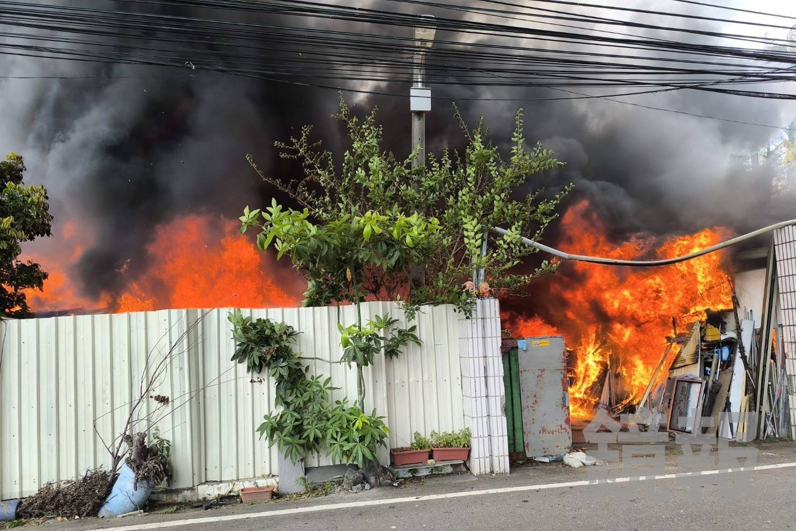 工廠空地堆置的材料與雜物突然起火,現場陷入一片火海,黑色濃煙不斷冒出。民眾提供