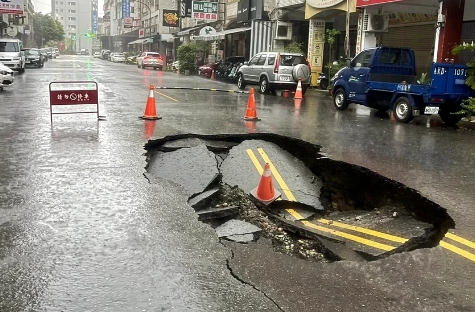 高雄豪大雨下不停,前鎮區廣西路柏油路面上午驚現天坑。翻攝記者爆料網