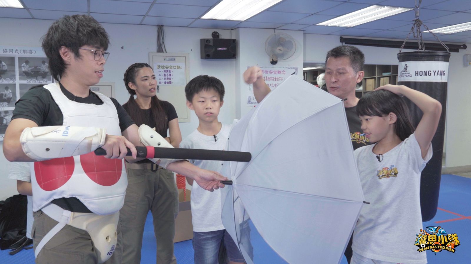 主持人宇宙(左二)、胡子(左一)及小隊員在「鹹魚訓練班」練習遇到無差別攻擊該如何防身。小公視提供