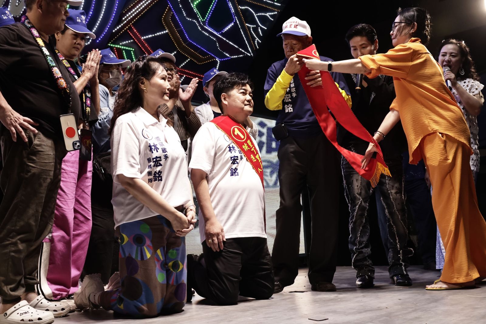 20261030林宏銘(中)攜女友林秀卿(左)當眾雙雙下跪,由88歲老父親親自披掛競選彩帶,場面溫馨感人。圖/林宏銘提供