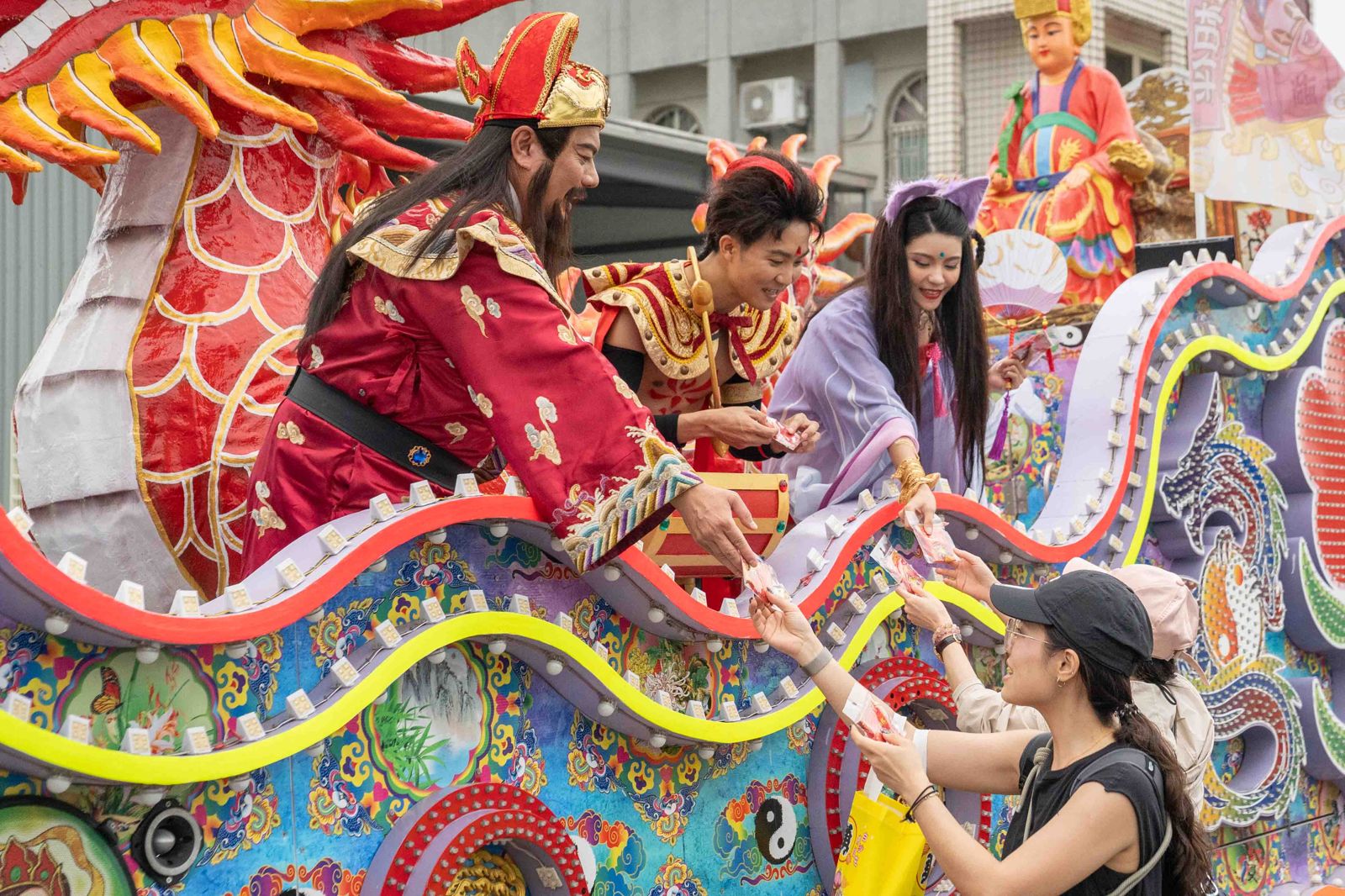 《戲說台灣》演員扮演遊戲角色：財神爺、三太子、狐仙現身藝閣車，發送「紅包魚錦囊」。圖／網銀國際提供