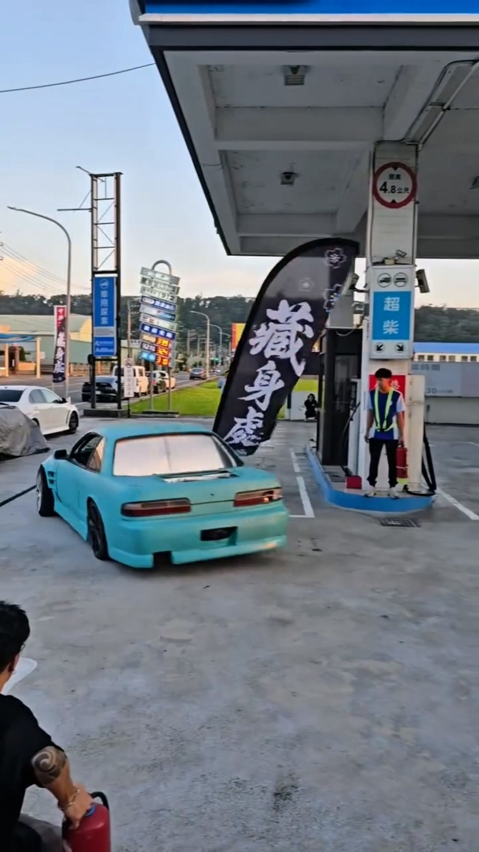 藍色改裝車在加油站內飄移甩尾，旁邊有工作人員持滅火器戒備，好幾位民眾拿著手機拍攝畫面。翻攝fb藍董