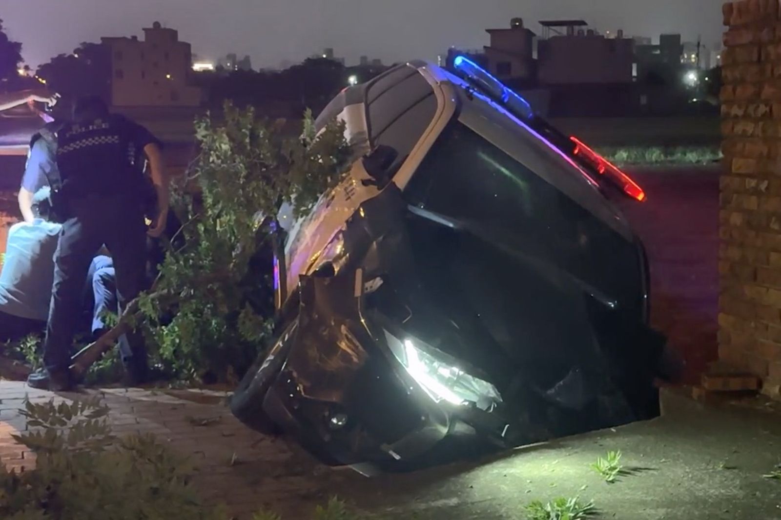 警車撞斷路樹卡在邊溝。民眾提供