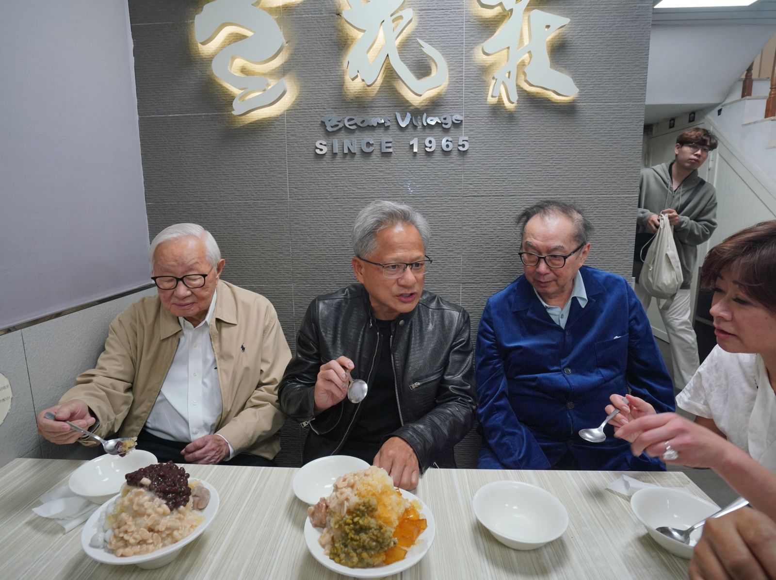 輝達執行長黃仁勳（中）作風親民，還曾拉著台積電創辦人張忠謀（左）、廣達董事長林百里（右）逛寧夏夜市、擠在一起吃豆花冰品。（鏡週刊提供）