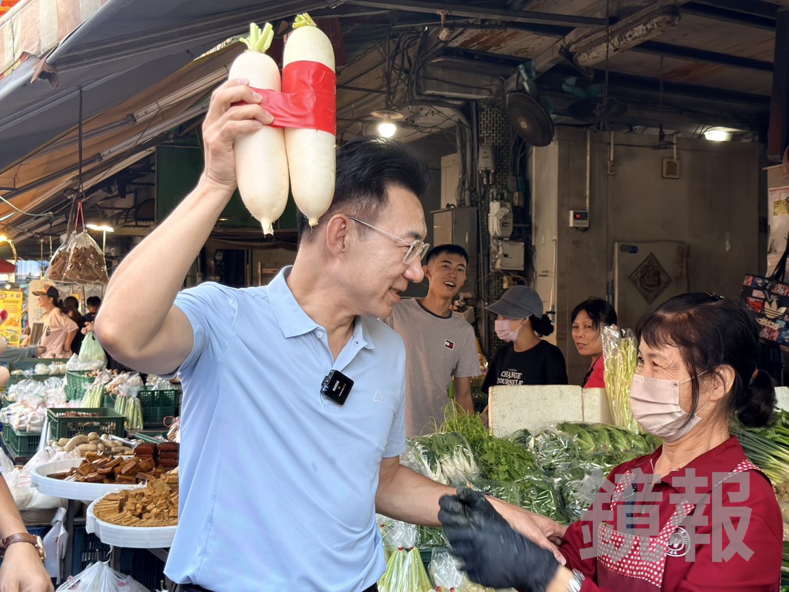 國民黨台中市長候選人江啟臣在大甲第二公有零售市場掃街拜票,攤商送上象徵「好彩頭」的菜頭。圖/江啟臣競總提供