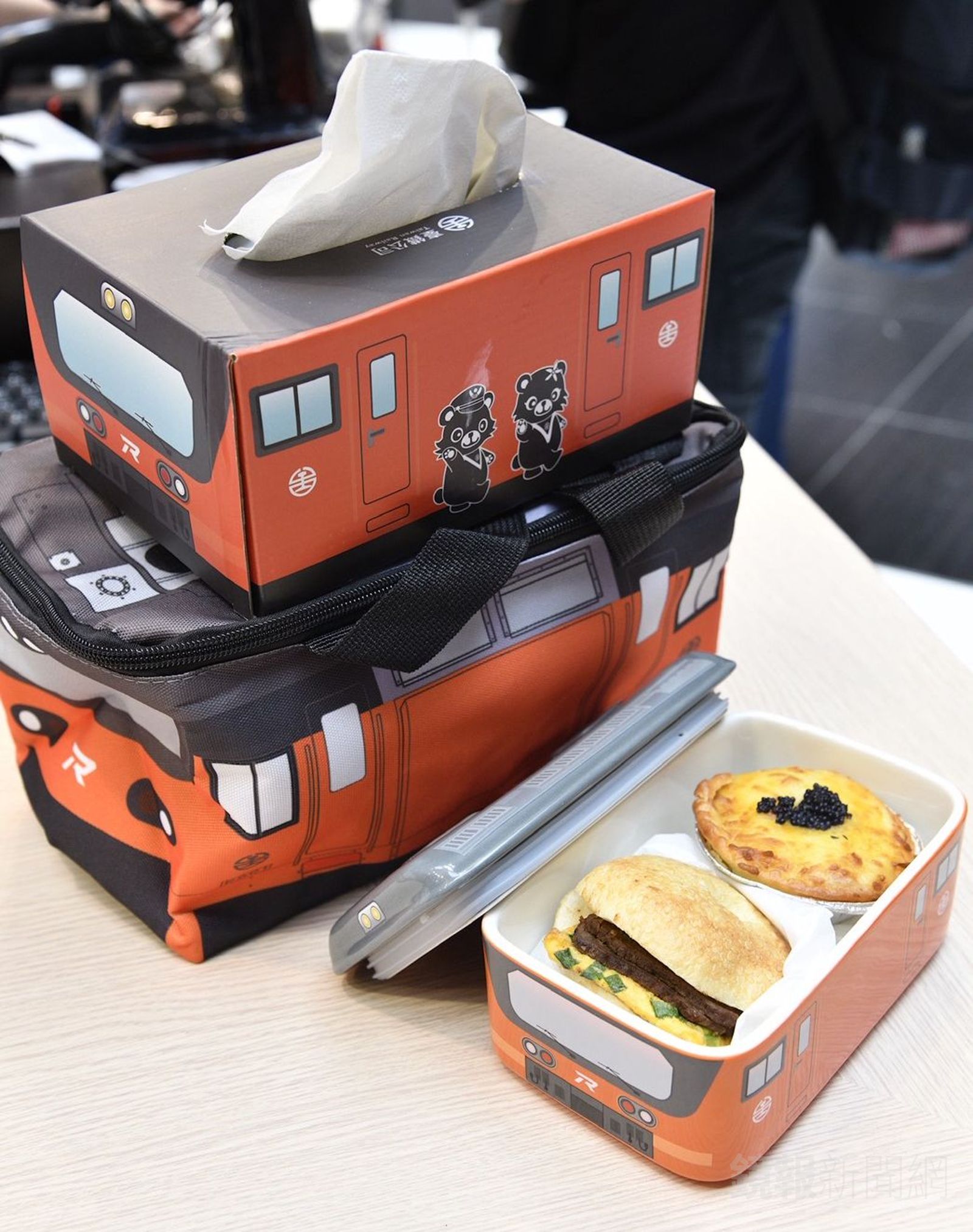 鐵道逎瘋搶的台鐵E500造型陶瓷便當盒，香酥餅皮夾入了A5和牛香煎蔥花蛋，搭配了有烏魚子點綴的海味法式鹹派。後方則是E500造型的面紙盒和保溫袋。