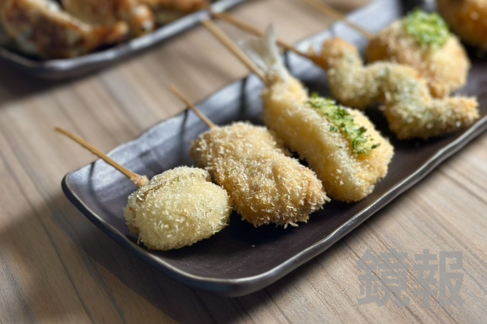 「葡萄串揚」一口咬下會爆汁，酸甜中又有起司鹹香。（35元／串，圖左）