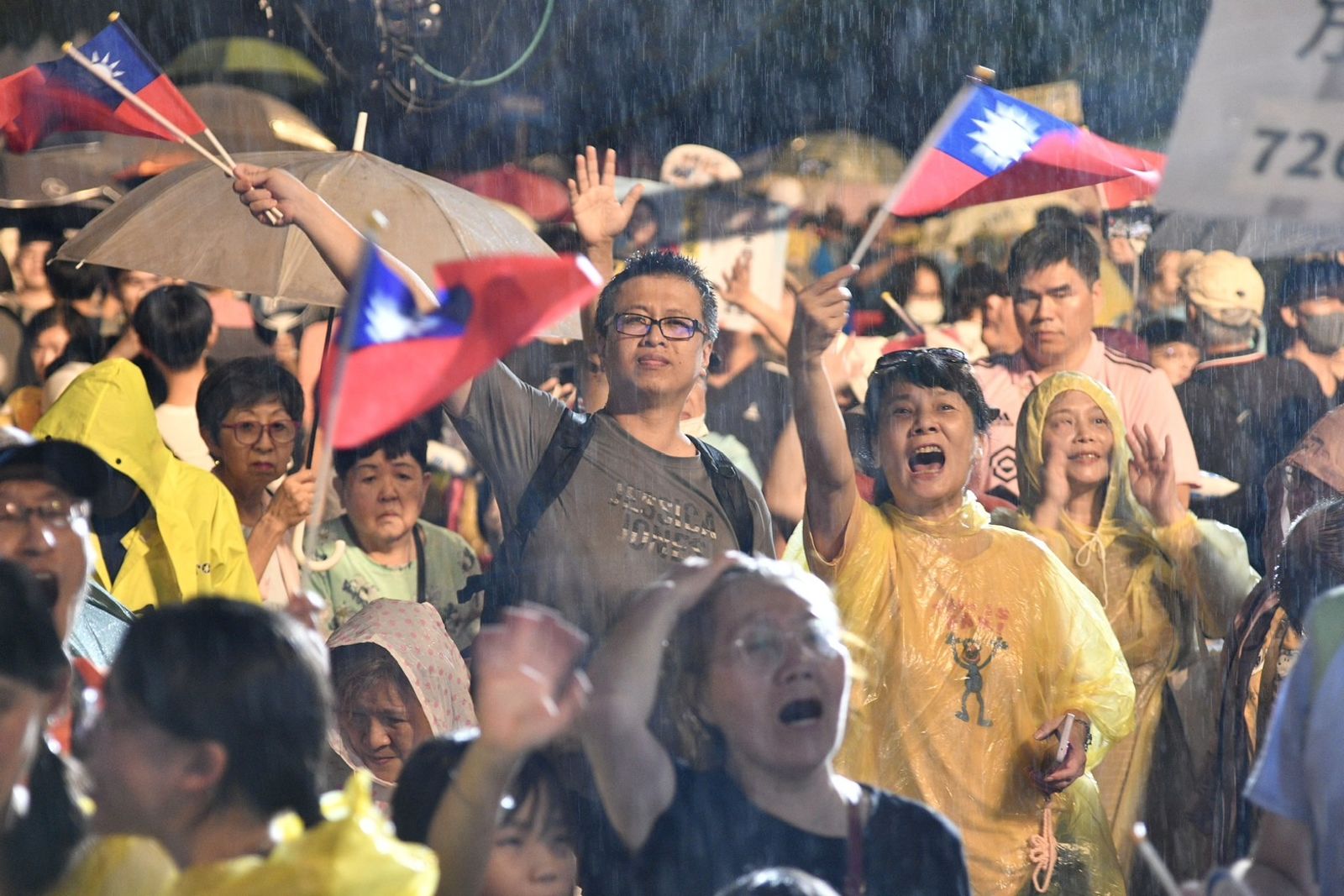國民黨今晚在凱道舉辦反罷選前之夜晚會,現場許多支持者不畏風雨,在台下熱情揮舞國旗、呼喊口號。(圖/李智為攝)