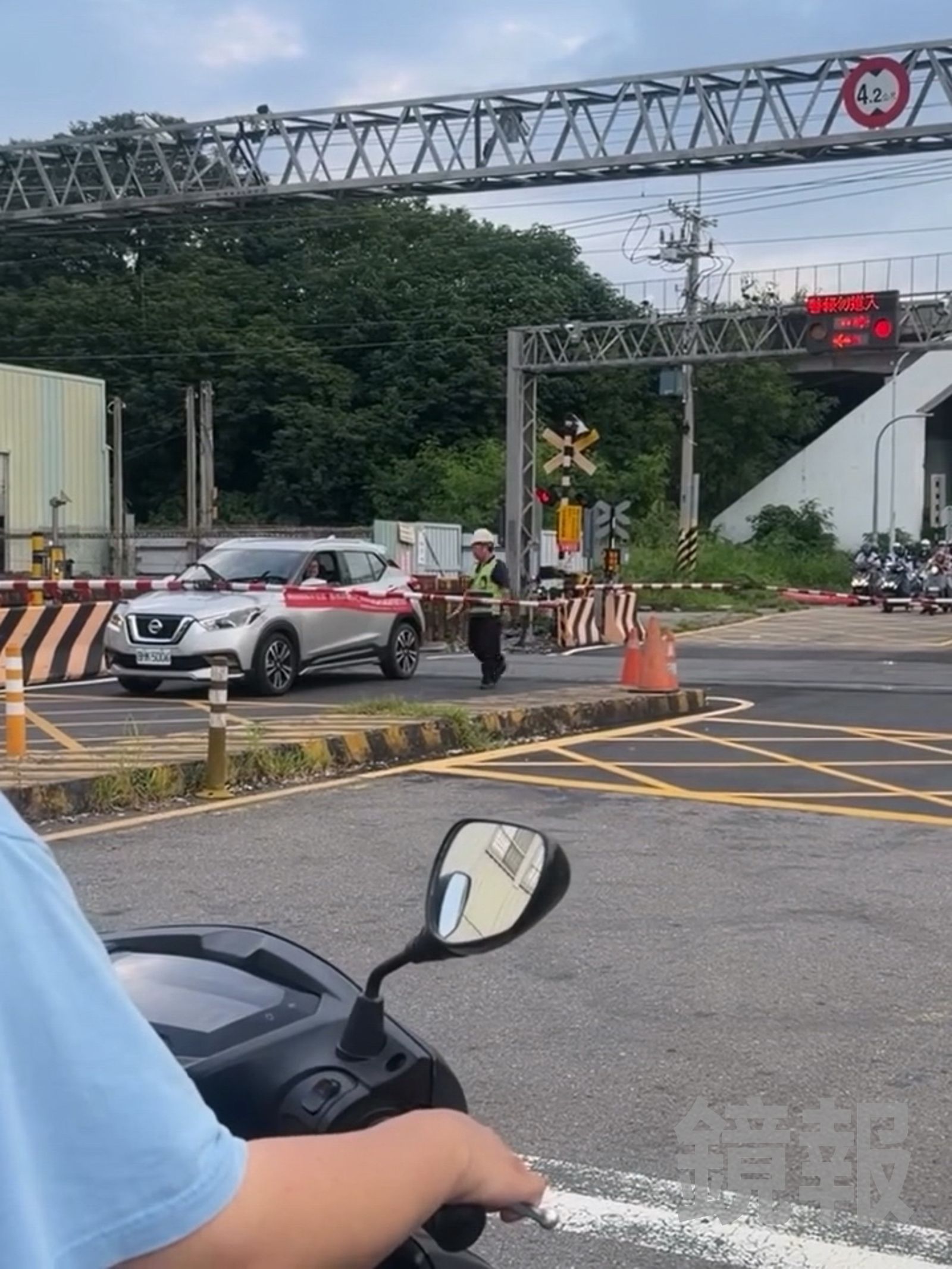 轎車停在平交道上，前後都已被柵欄放下圍住，保全人員趕緊過去協助，現場情況一度相當緊急。畫面翻攝threads 