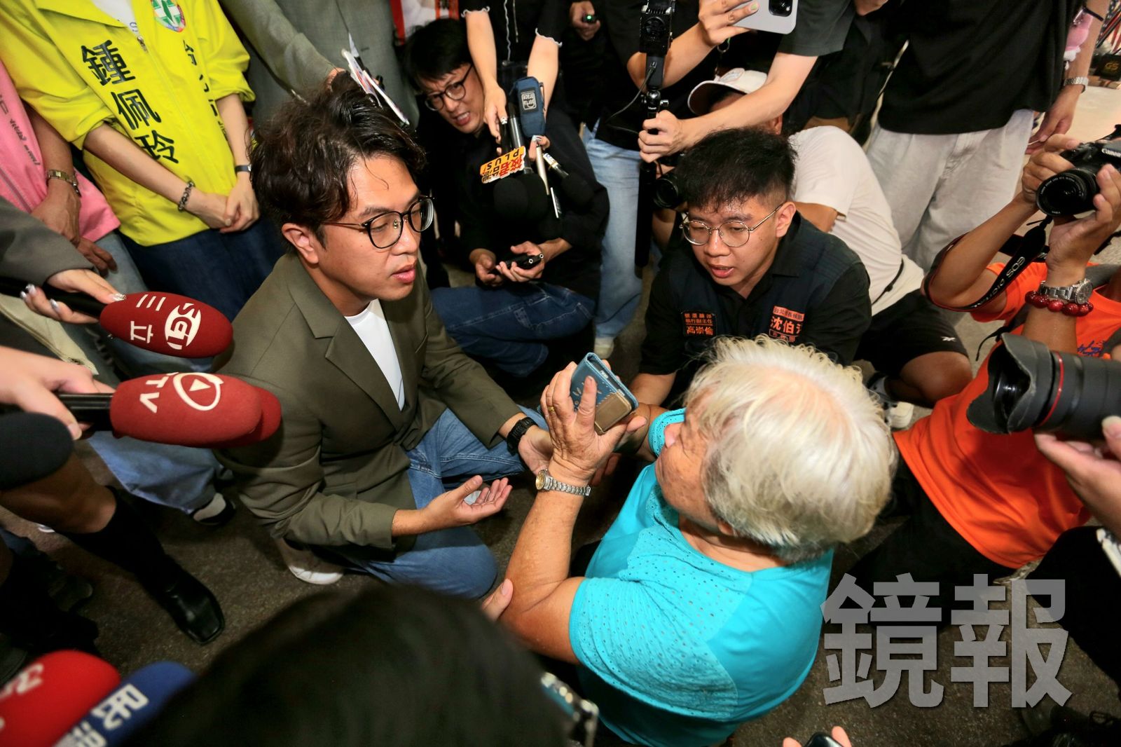 民進黨台北市長候選人沈伯洋(左)今(17日)赴社子島參香,一名阿嬤(右)雙膝跪地陳情,盼沈當選後照顧社子島窮苦居民。攝影姜永年