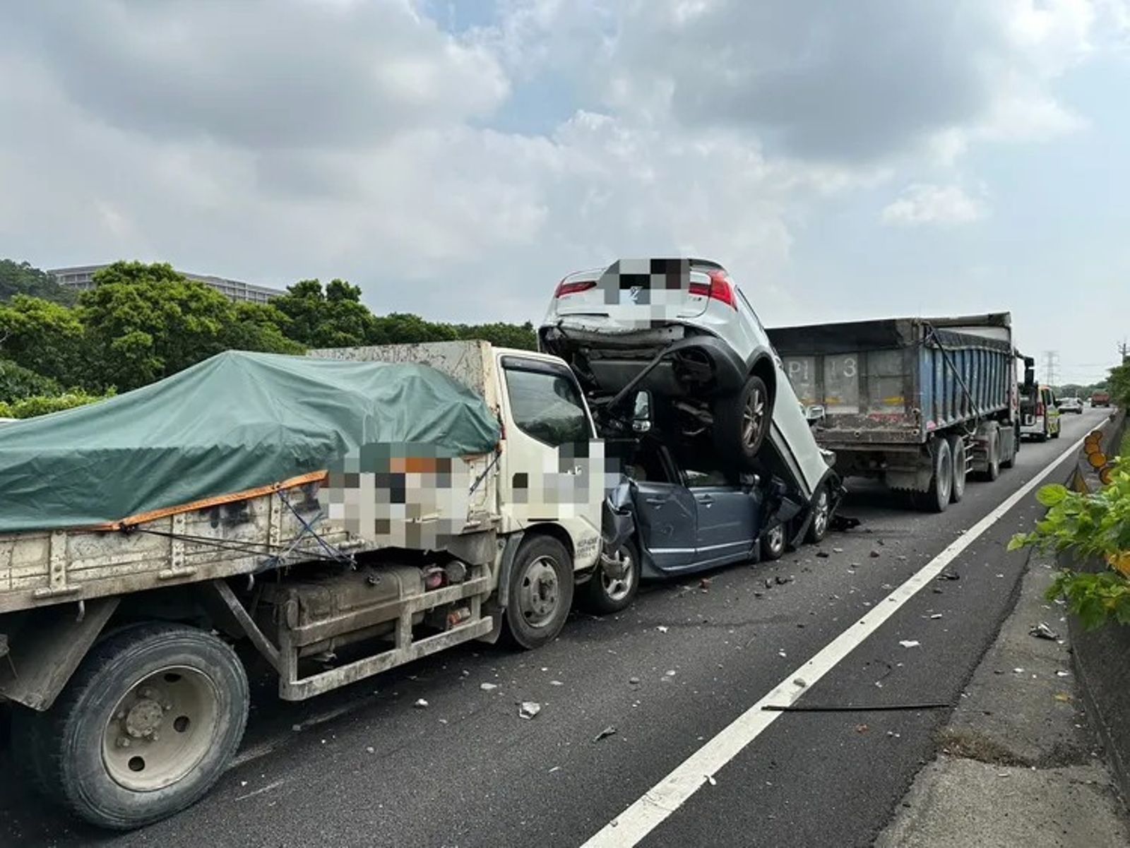 國道3號大溪北上路段發生4車連環車禍，其中1輛白色轎車被鏟起騰空，夾在2車之間。桃園市消防局提供