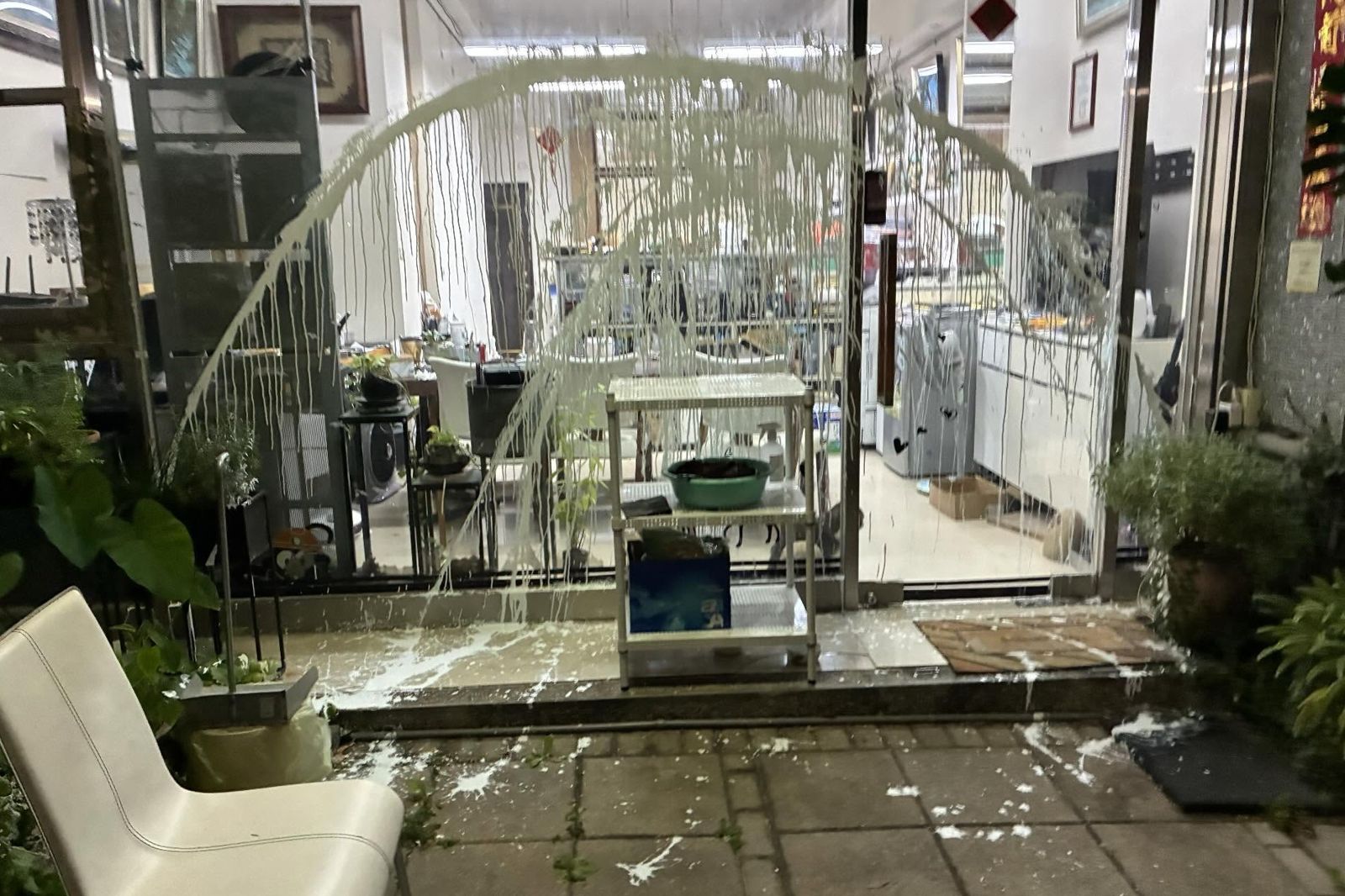 店家玻璃門與門口都是白色油漆污漬。翻攝threads leochiu0717