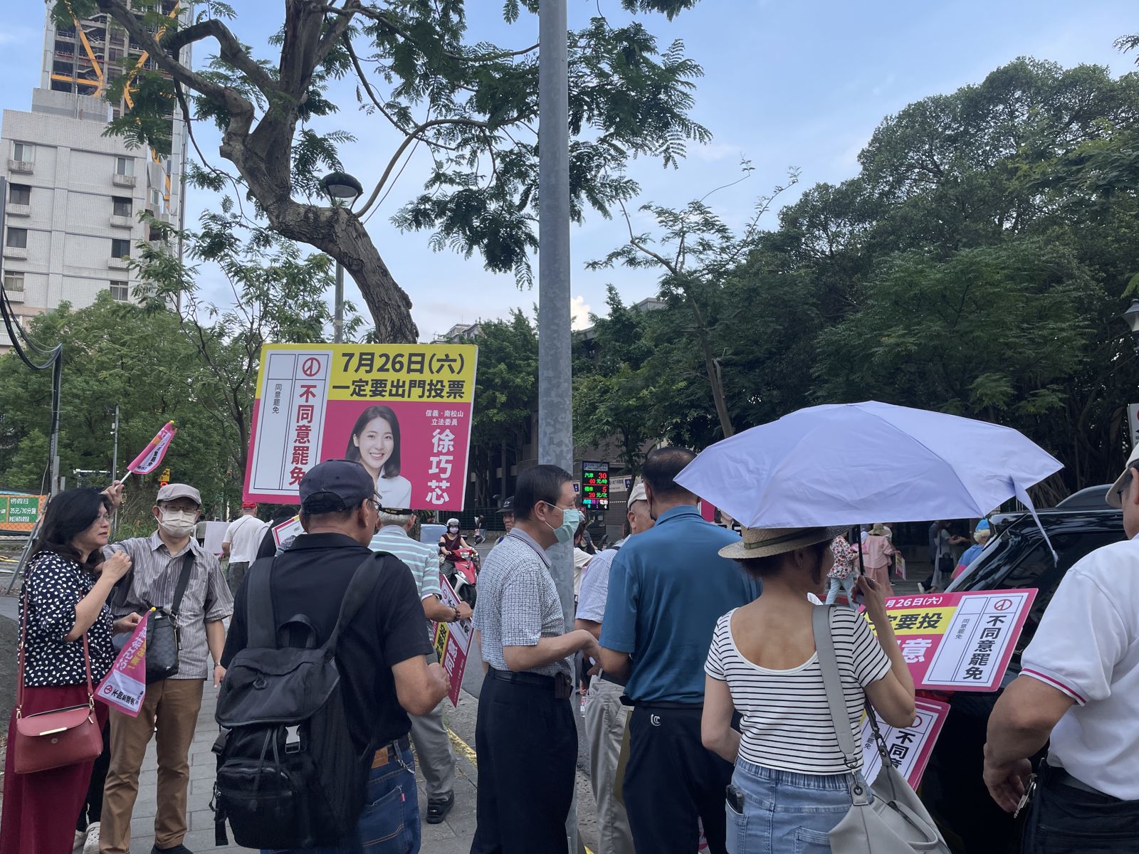 在車掃開始前,路旁早已聚集十多名支持者,手持不同意罷免等標語牌迎接。(圖/陳凱貞攝)