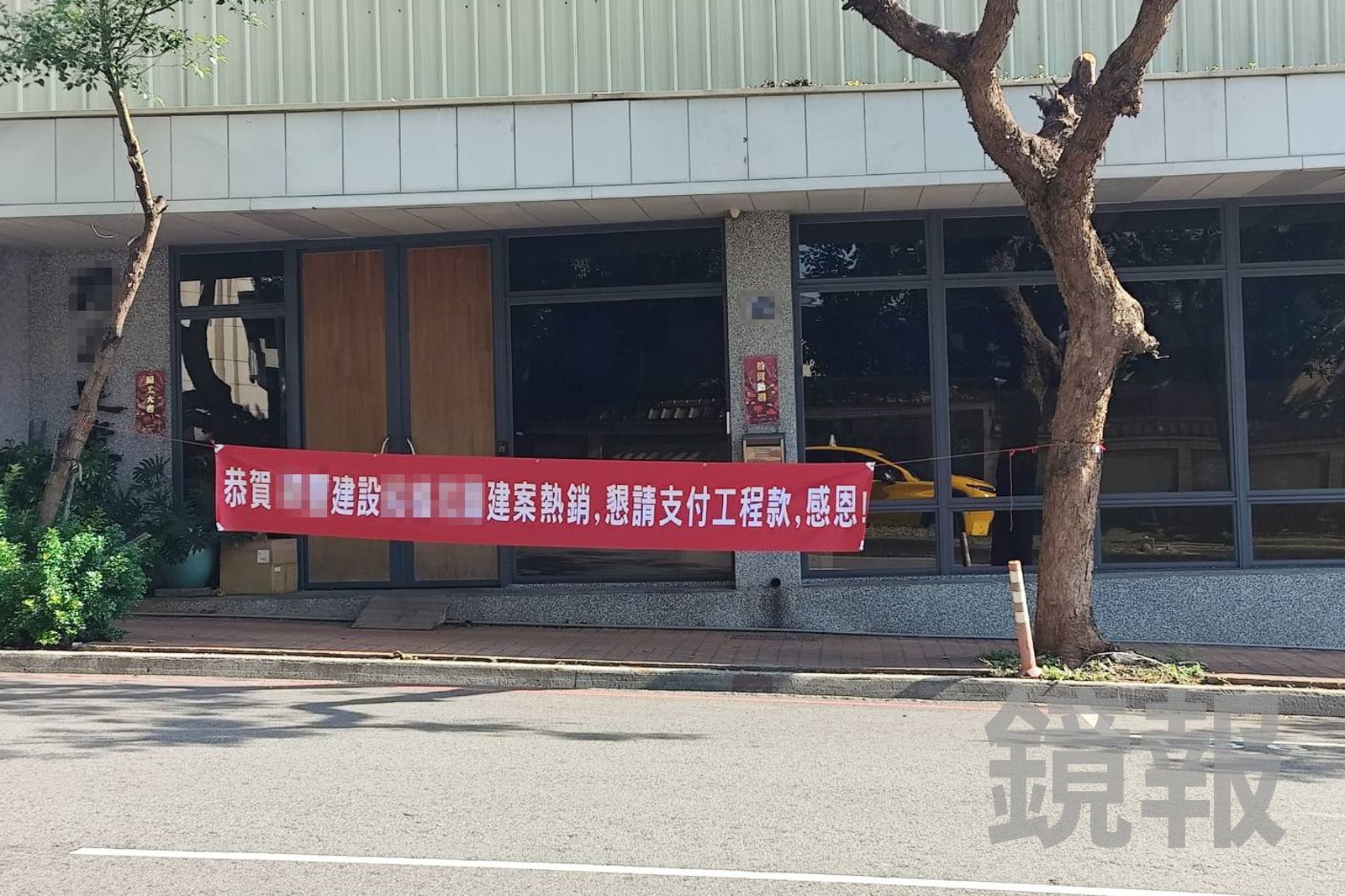 建設公司門口被包商掛上紅布條,上頭「恭賀建案熱銷,懇請支付工程款」的字樣諷刺意味濃厚。民眾提供
