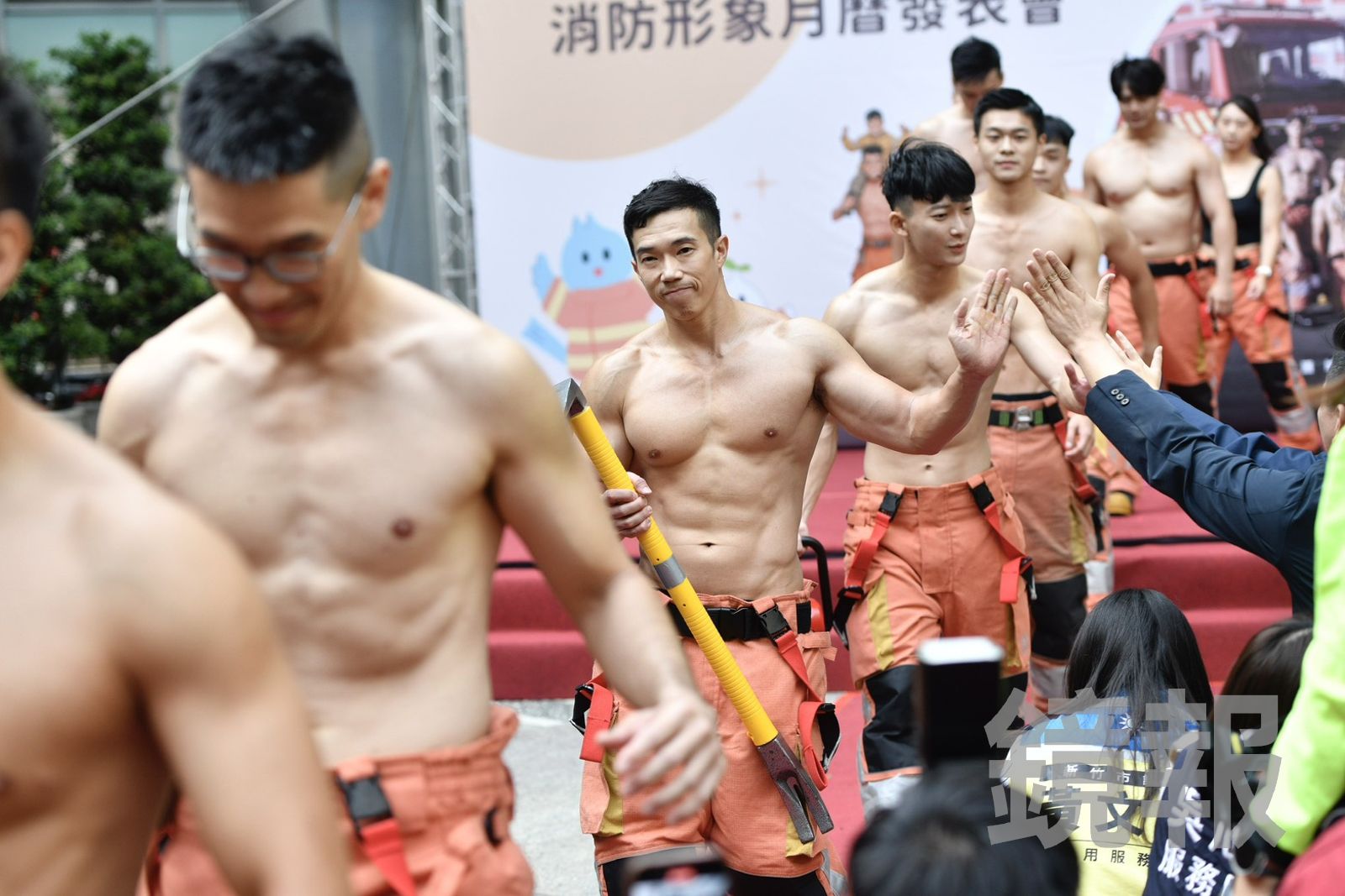新竹市消防猛男輪番上陣,大秀結實的冰塊腹肌,宣傳2026年消防形象宣導月曆。(圖/李智為攝)