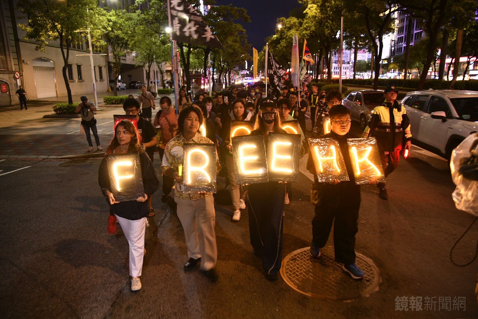參加的民眾手持發光的「FREE HK」標語，在夜晚中特別顯眼。