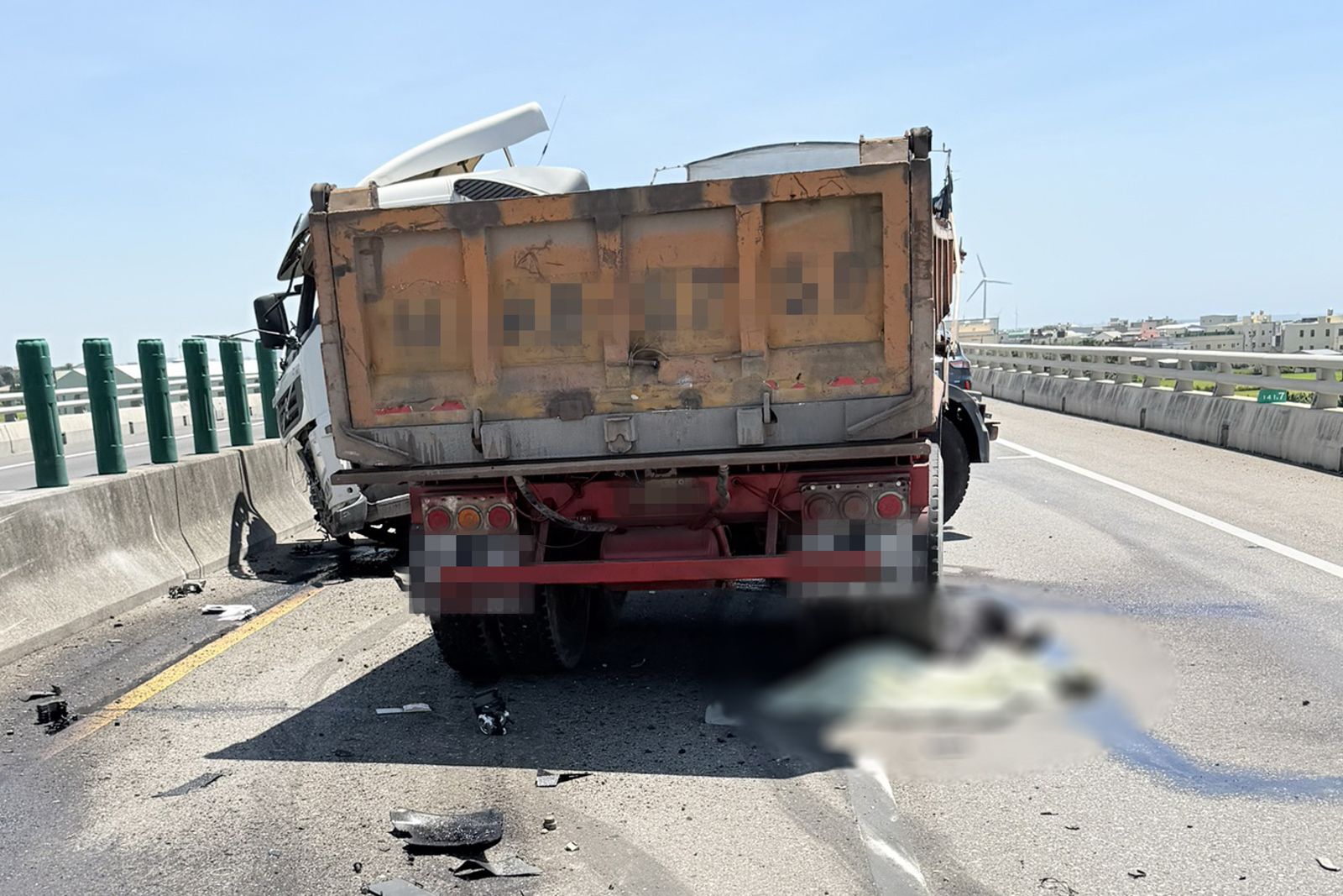 砂石車駕駛疑自撞護欄、噴飛車外，被自己的車子後輪輾壓，當場臟器外露，明顯死亡。民眾提供