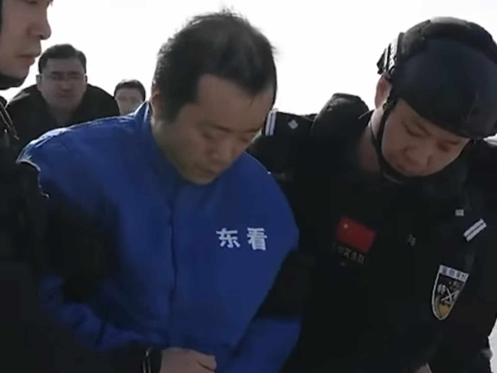 陳志雙手上銬帶著腳鐐,在特警戒護走下飛機。翻攝柬中時報