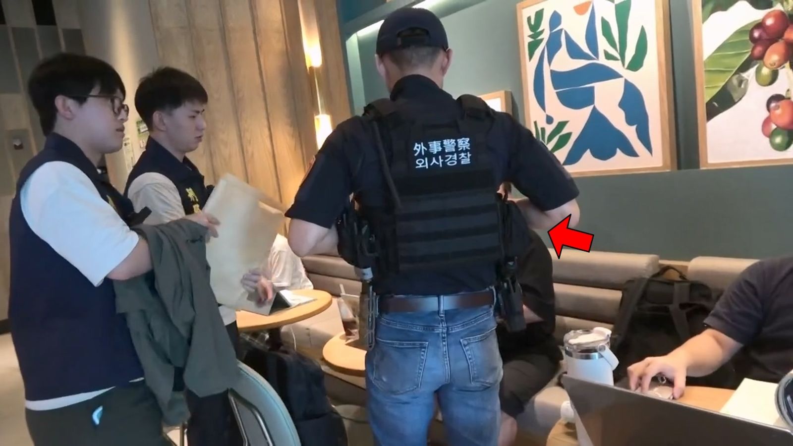 苗栗警方出動外事警察翻譯，在咖啡廳拘提韓籍金姓男子(箭指處)。民眾提供