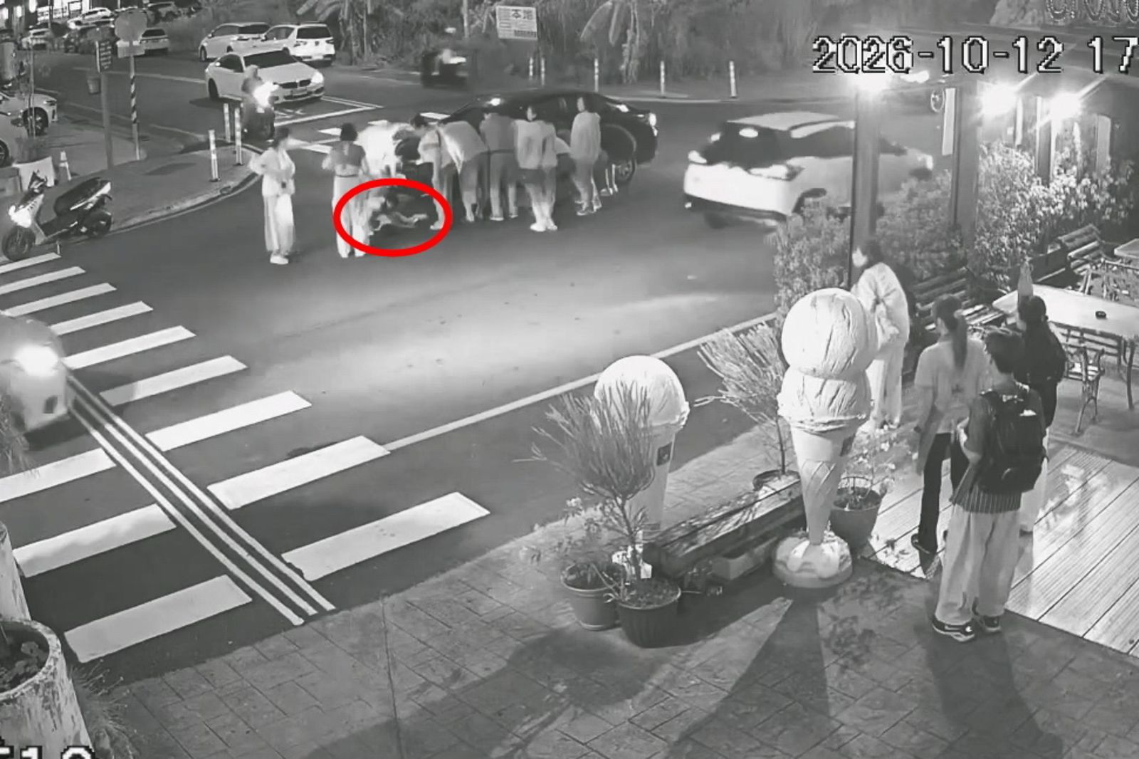 附近民眾合力抬起車子,將受困車底的男童(紅圈處)救出。圖/民眾提供