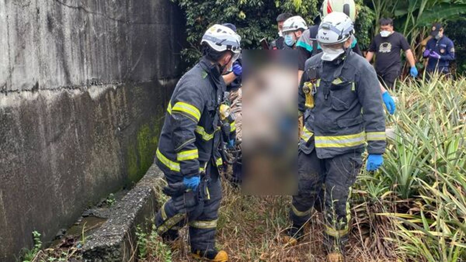 警消將遺體移出荔枝園，交由鑑識小組調查採證。民眾提供